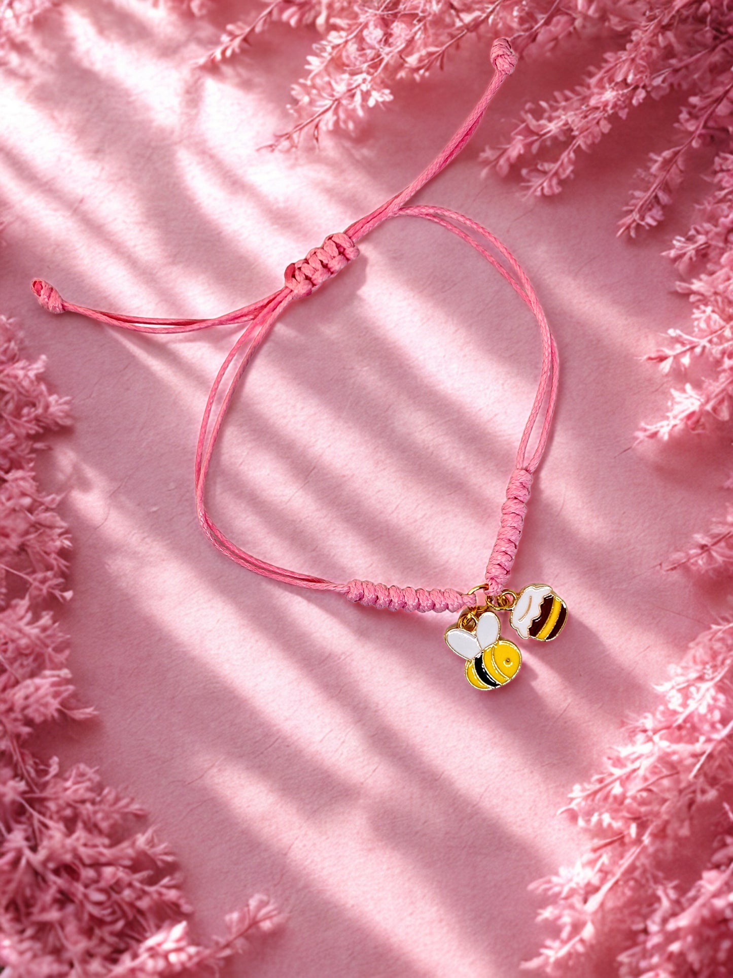 Pink cord bracelet with a bee and honey pot charms