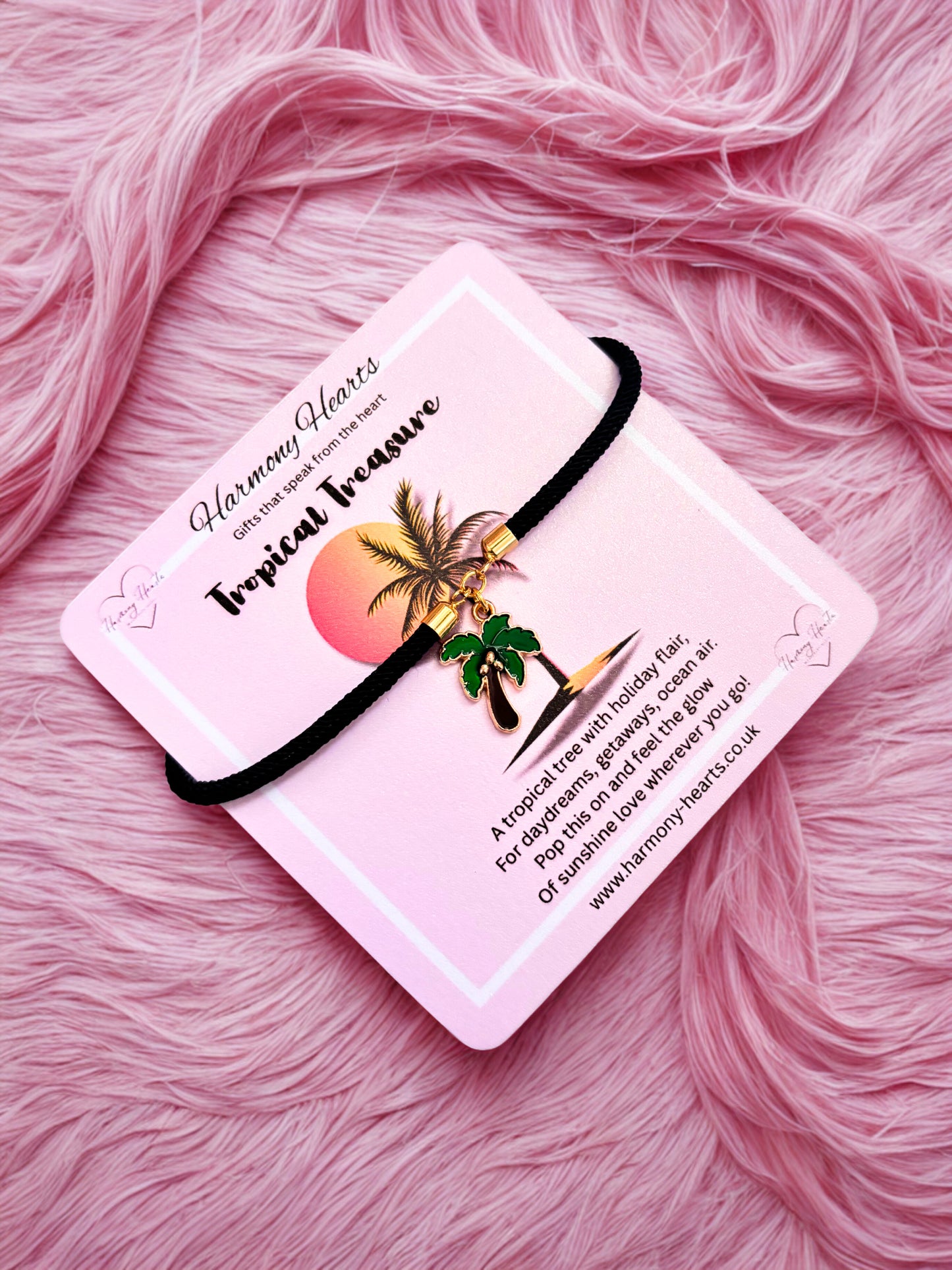 Bracelet with tropical design on a pink card against a pink fluffy background