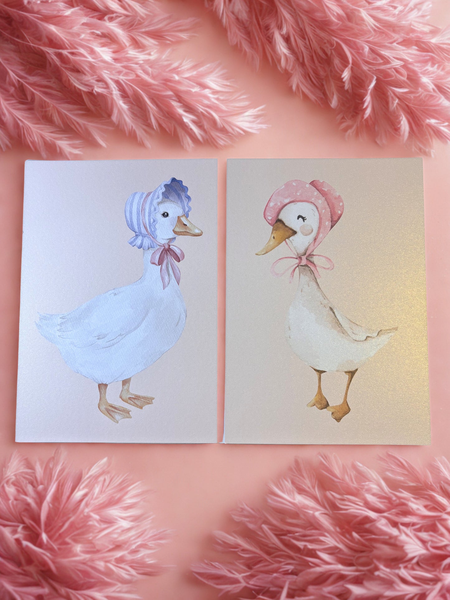 Two illustrated ducks wearing hats on a pink textured background