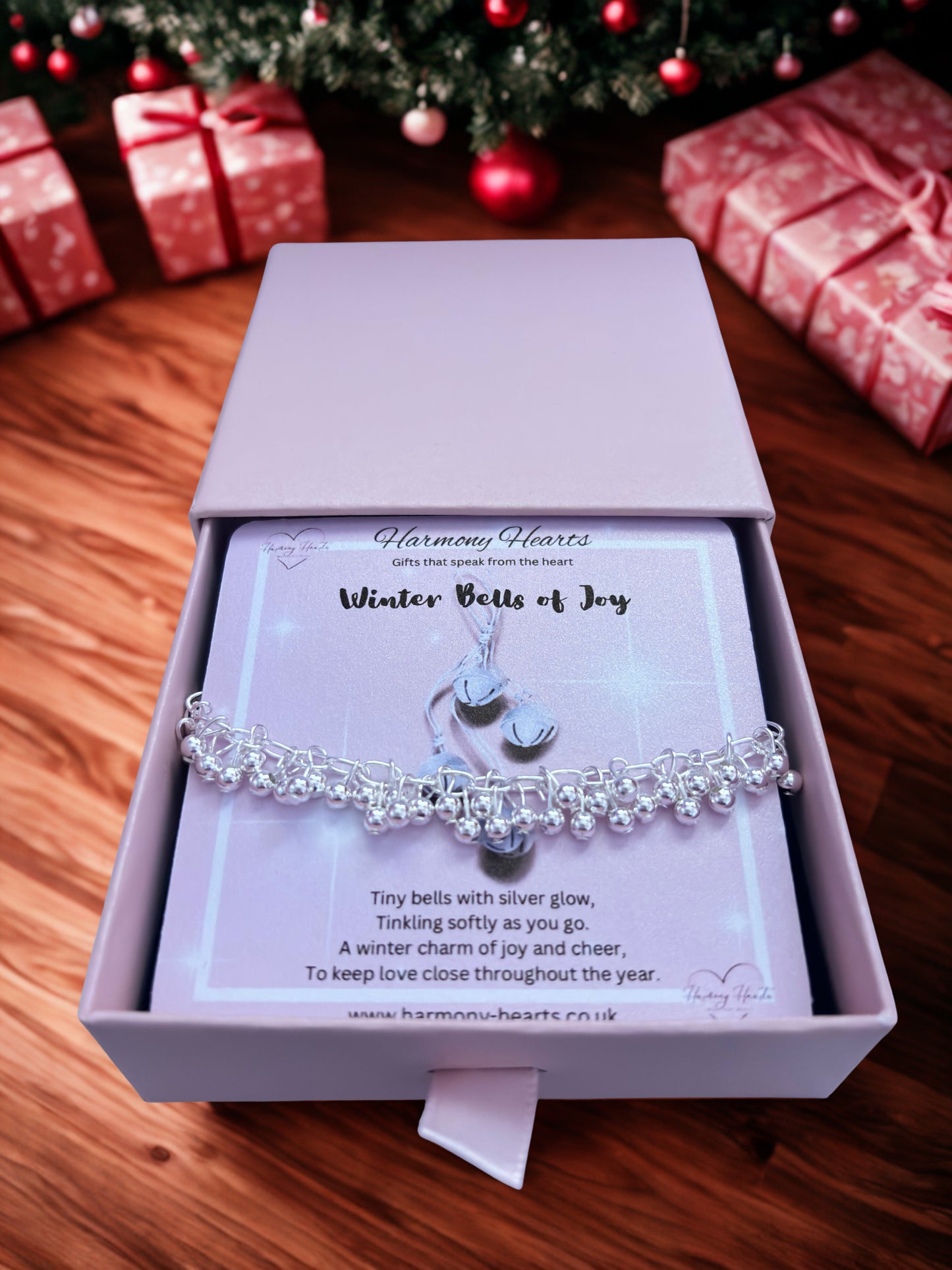 Silver bell bracelet in a box with Christmas decorations in the background