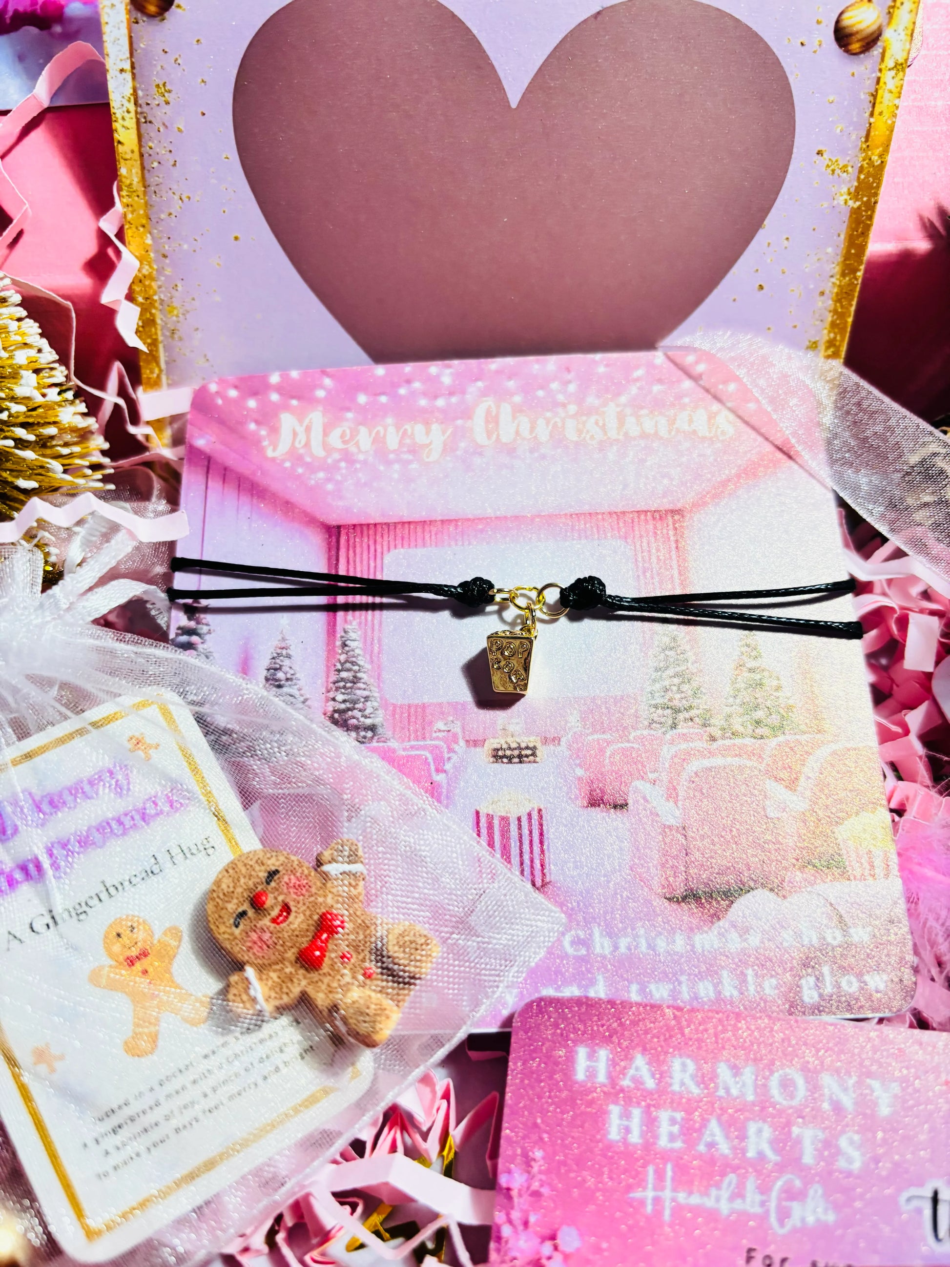Pink Christmas-themed product with a gingerbread man charm and decorative packaging.