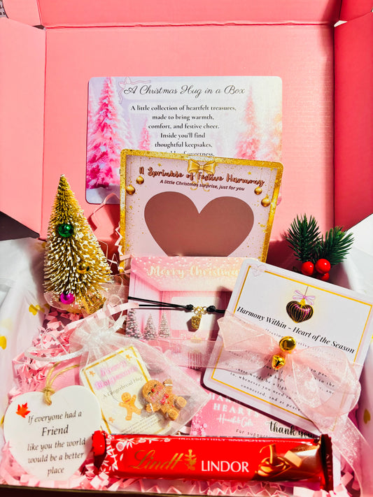 Pink gift box with various items including Lindt chocolate, cards, and small decorative items.
