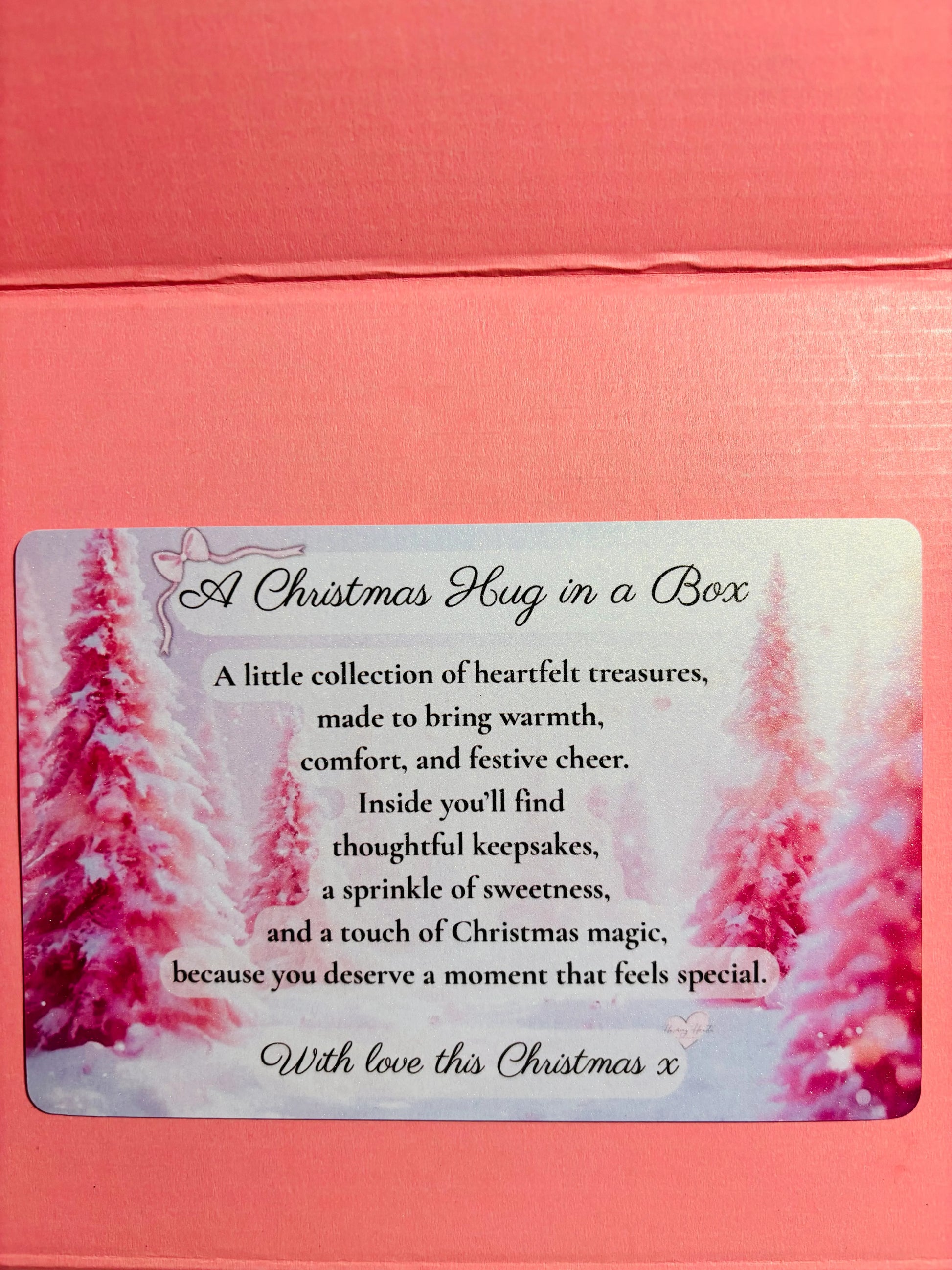 Pink box with a Christmas-themed card on a pink background