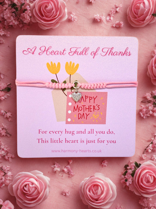 Pink cord bracelet with a silver sparkly charm presented on a 'Happy Mother's Day' card on a pink floral background