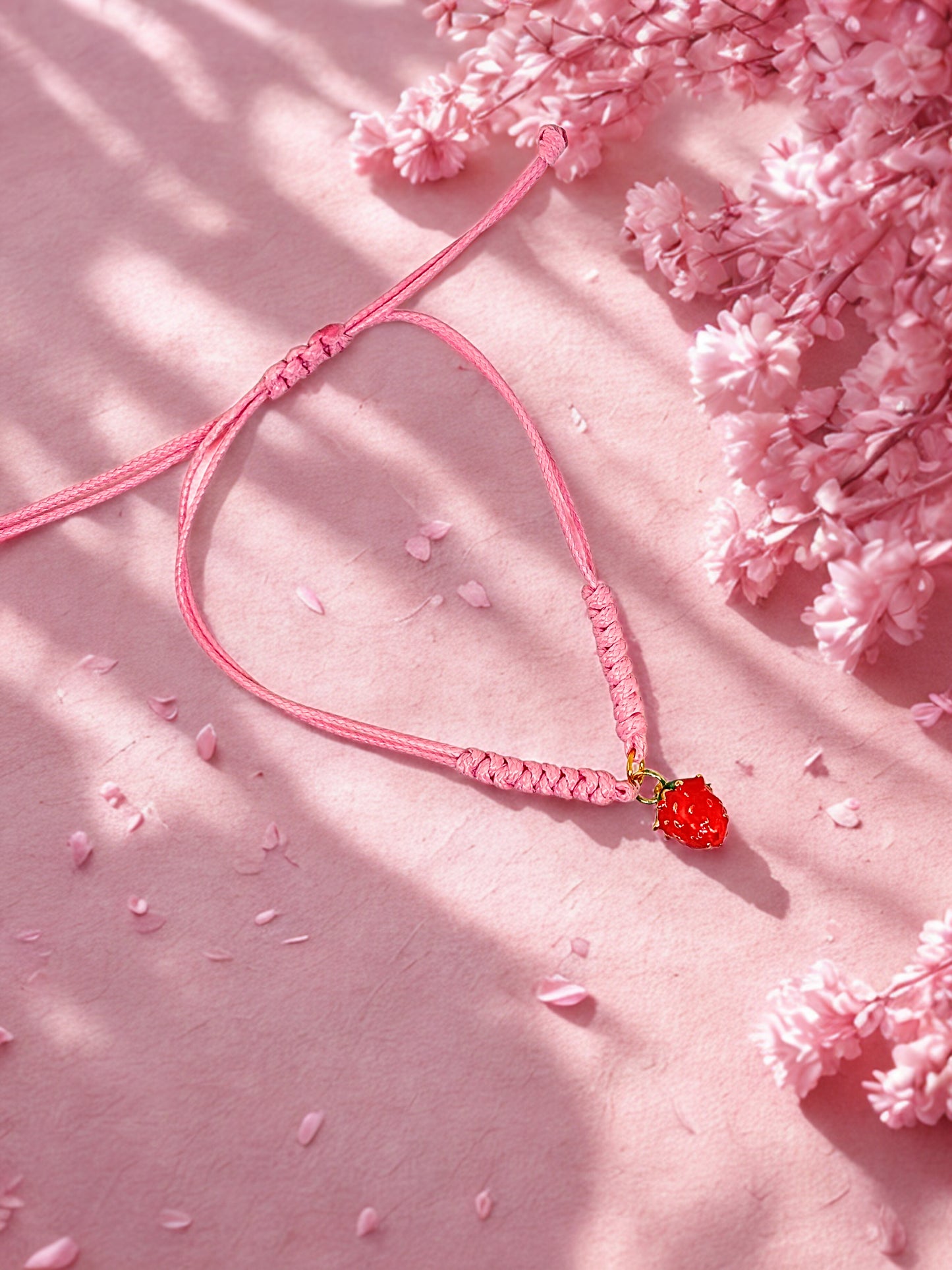 pink cord bracelet with a strawberry charm