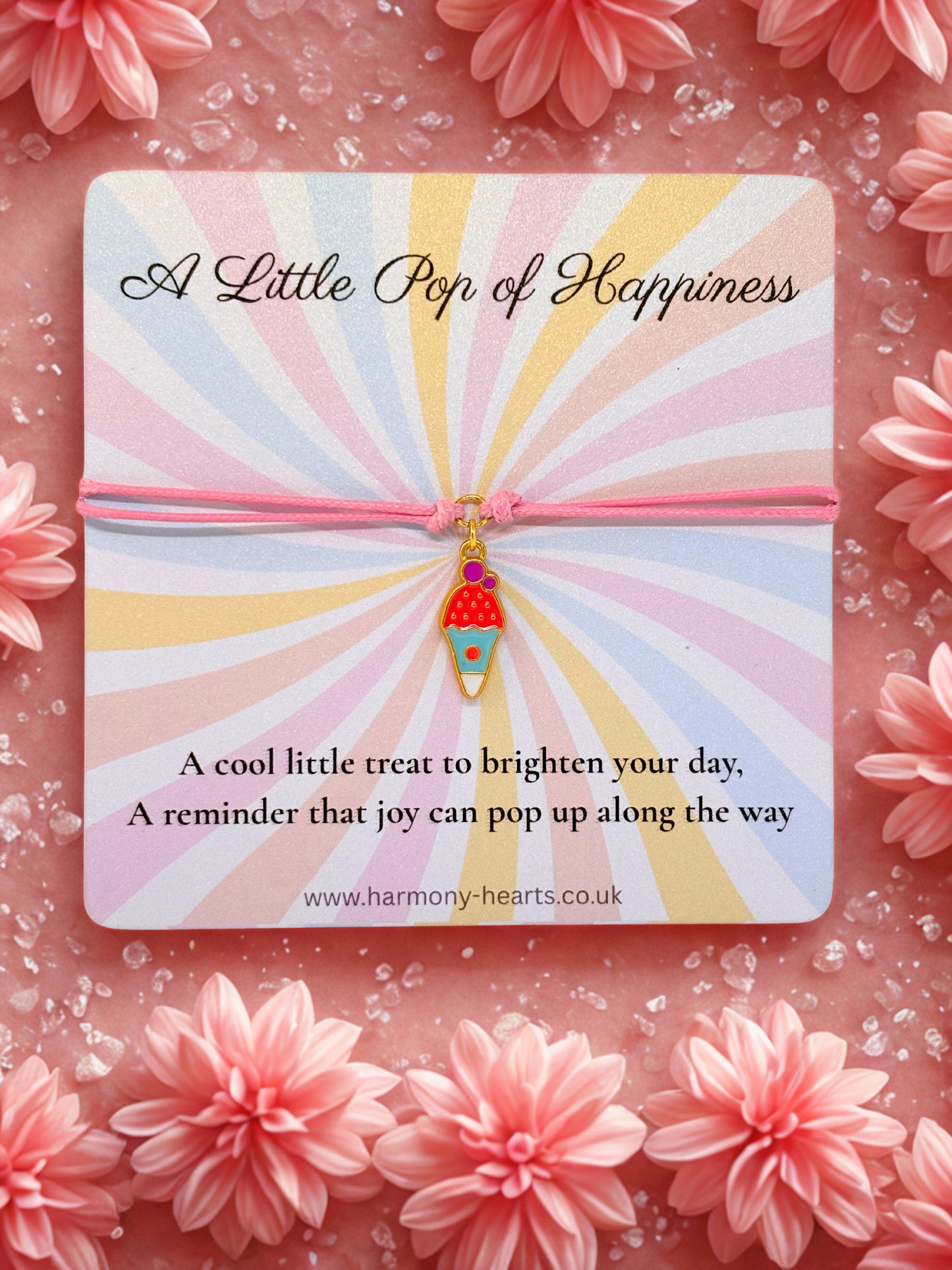 Card with 'A Little Pop of Happiness' message and pink ice cream charm bracelet on a floral background