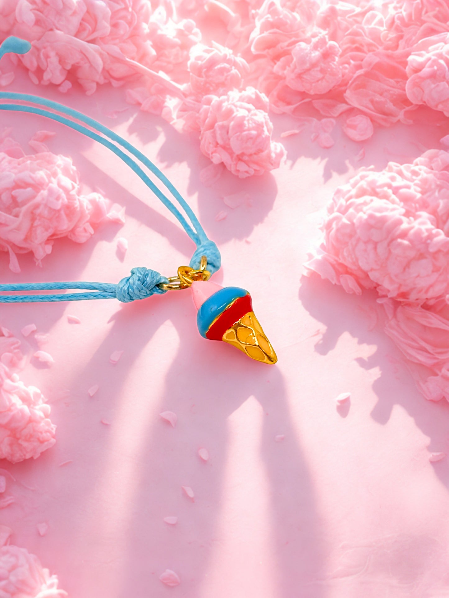 blue and gold ice cream cone charm on a pink floral background