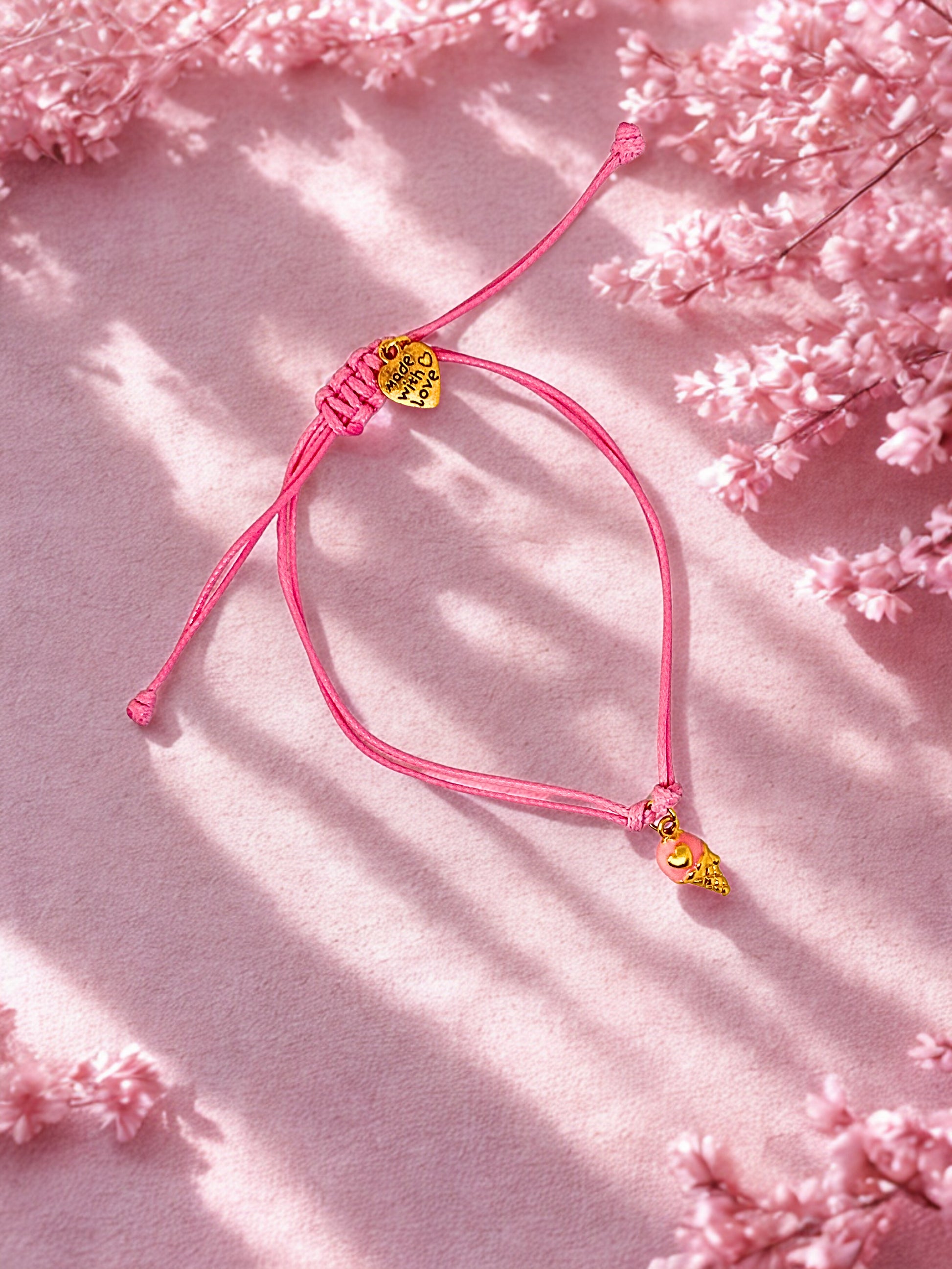 Pink bracelet with ice cream charm on a pink floral background