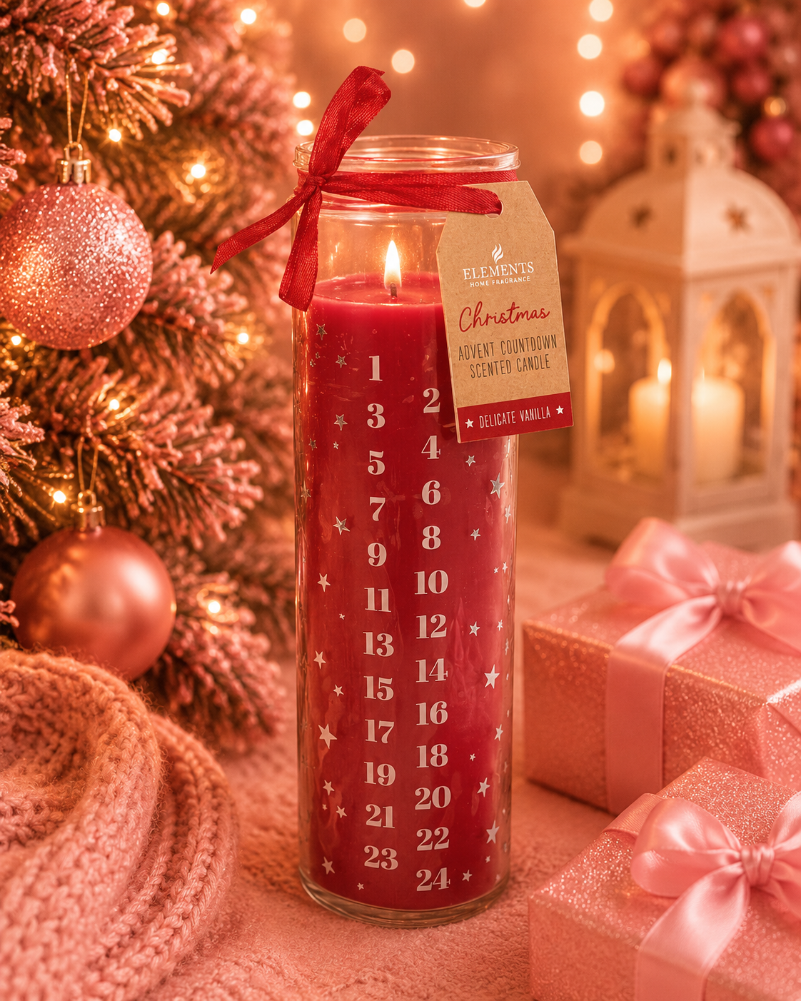 A red Christmas advent candle in a tall glass jar with a lit flame, decorated with white numbers 1 through 24 and small white stars. A red ribbon and a paper tag reading 'FLEMMINGS Christmas Advent Countdown Scented Candle' are tied around the jar.
