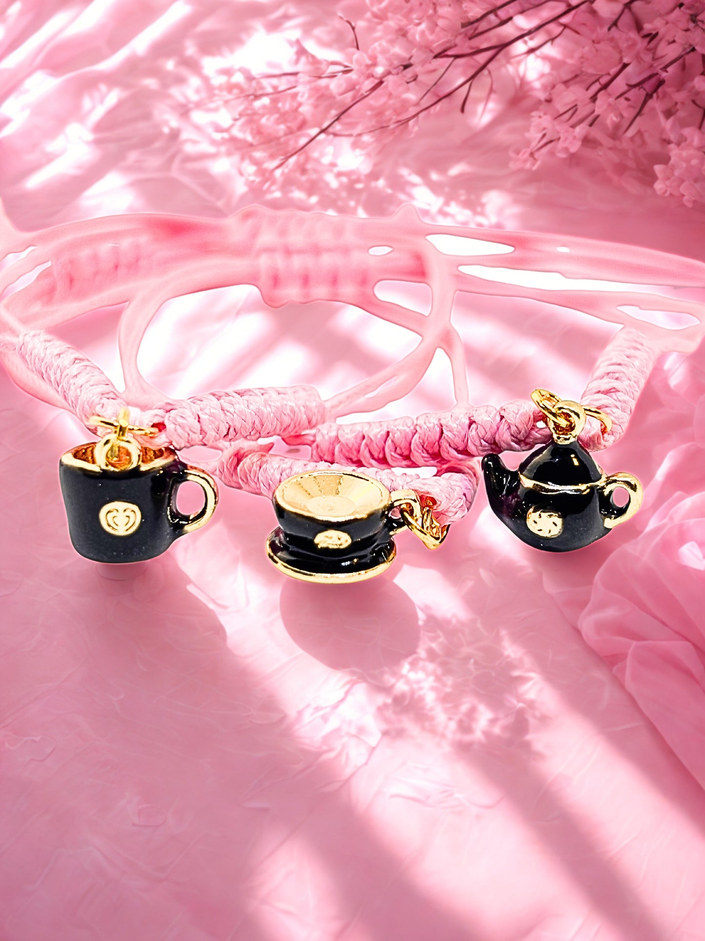 Bracelet with teacup and teapot charms on a pink background