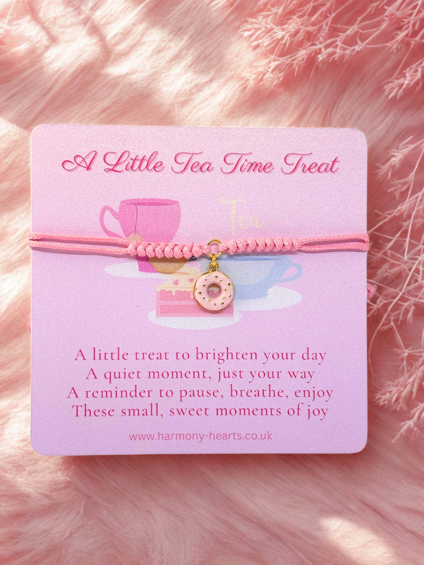 Pink cord bracelet with a pink donut charm presented on a branded Harmony Hearts poem card