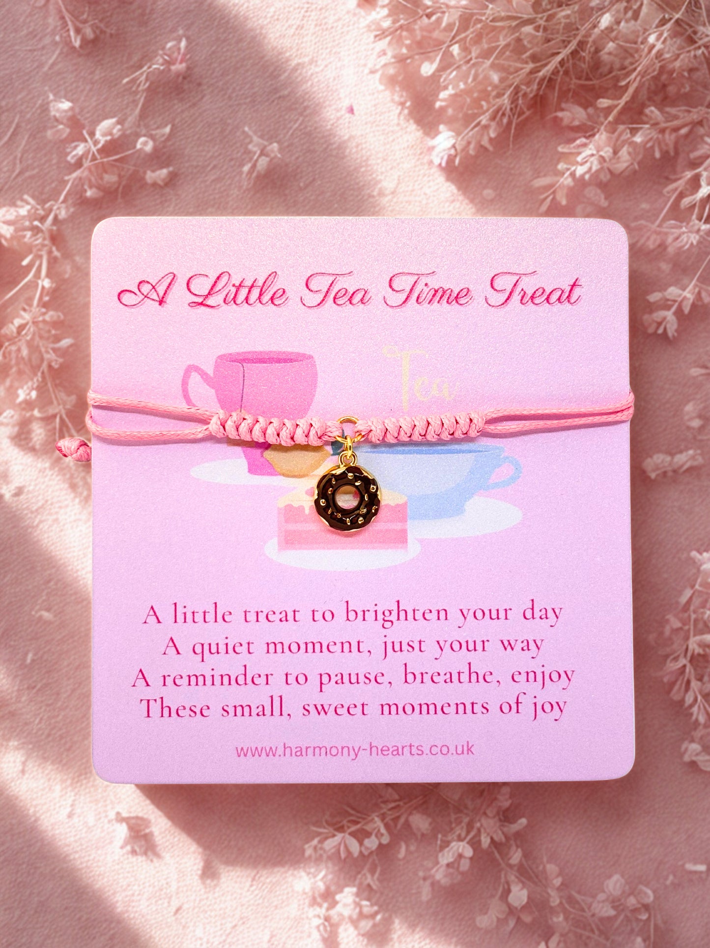 Pink cord bracelet with a chocolate donut charm presented on a branded Harmony Hearts card