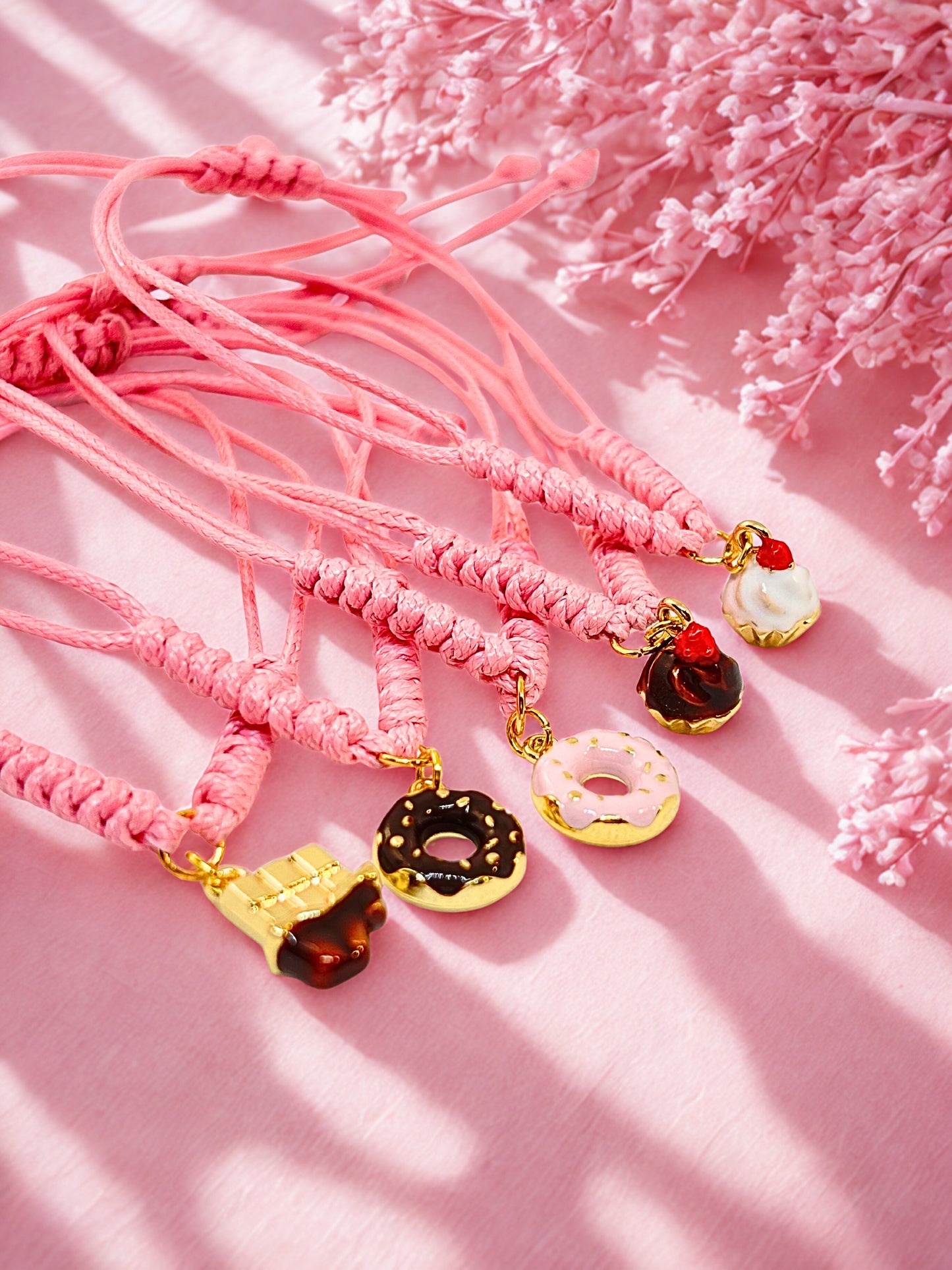 Pink cord bracelets with cake inspired charms