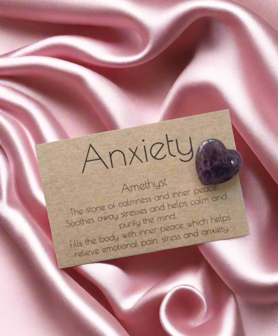 Amethyst stone on a card labeled 'Anxiety' on pink satin fabric