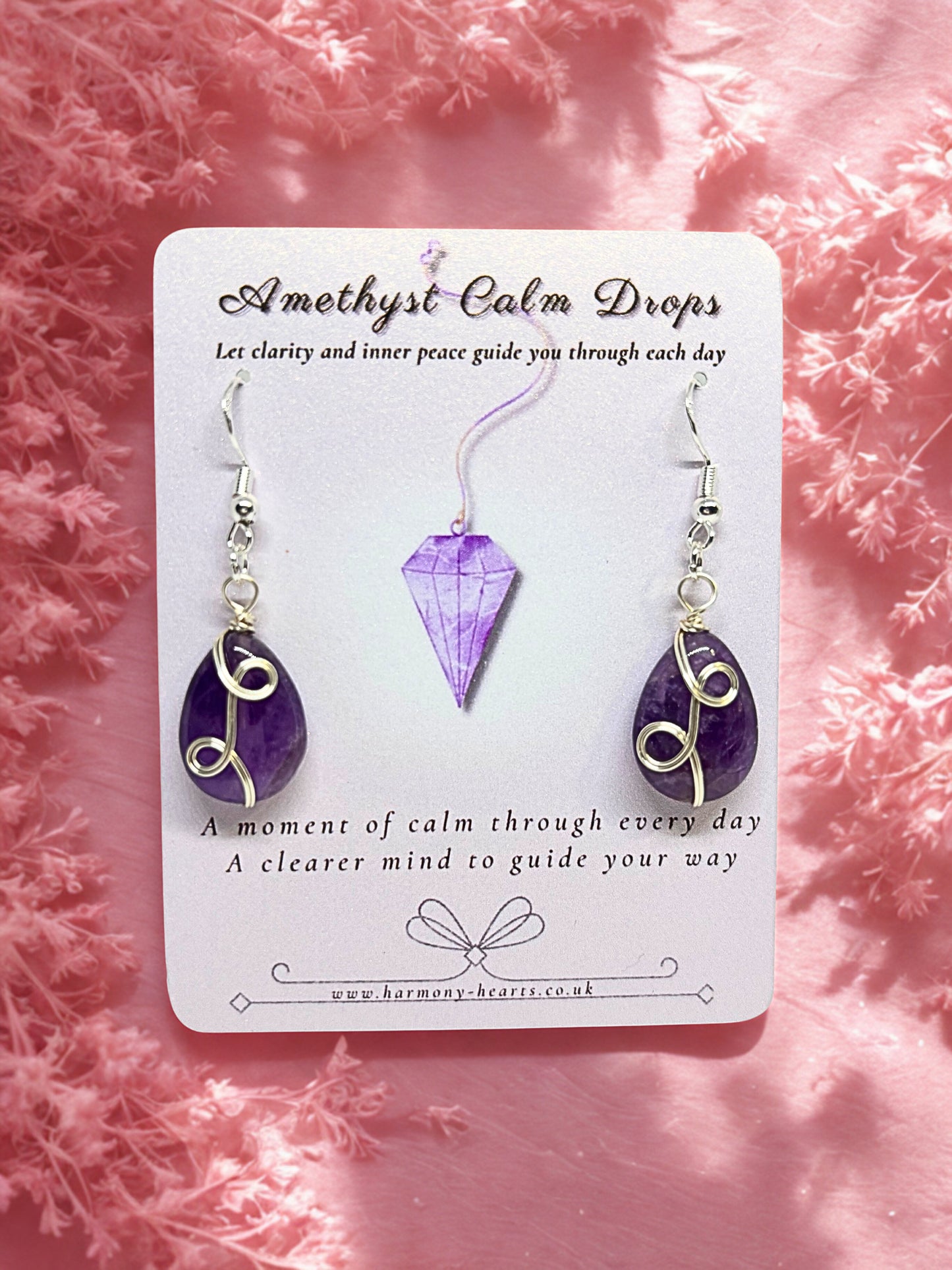 Amethyst earrings on a card with pink floral background