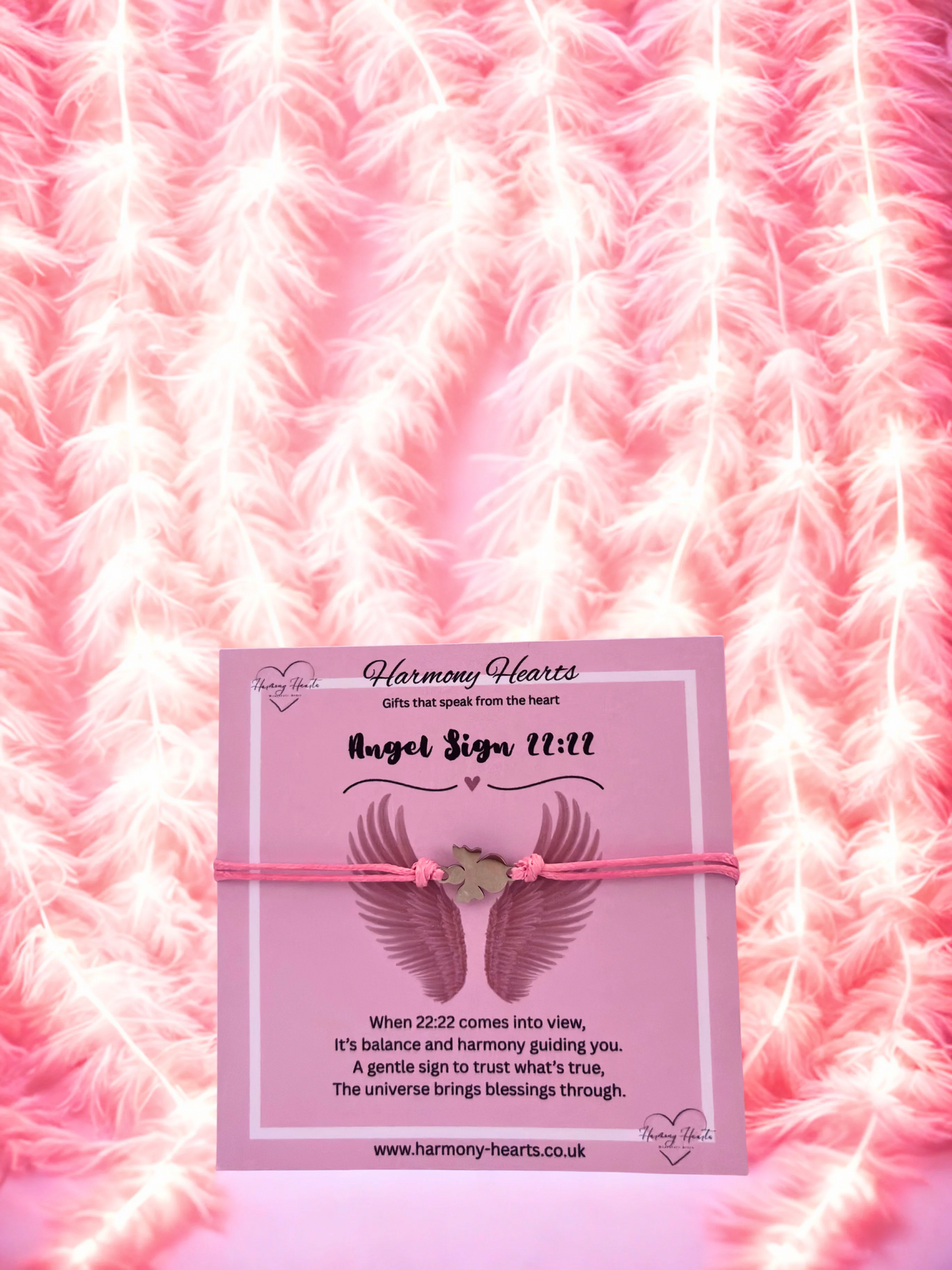 Pink card with angel wings and text on a pink feather background