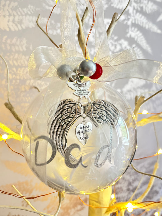 Clear Christmas bauble with an angel wings keepsake inside and Dad on the outside with glitter letters