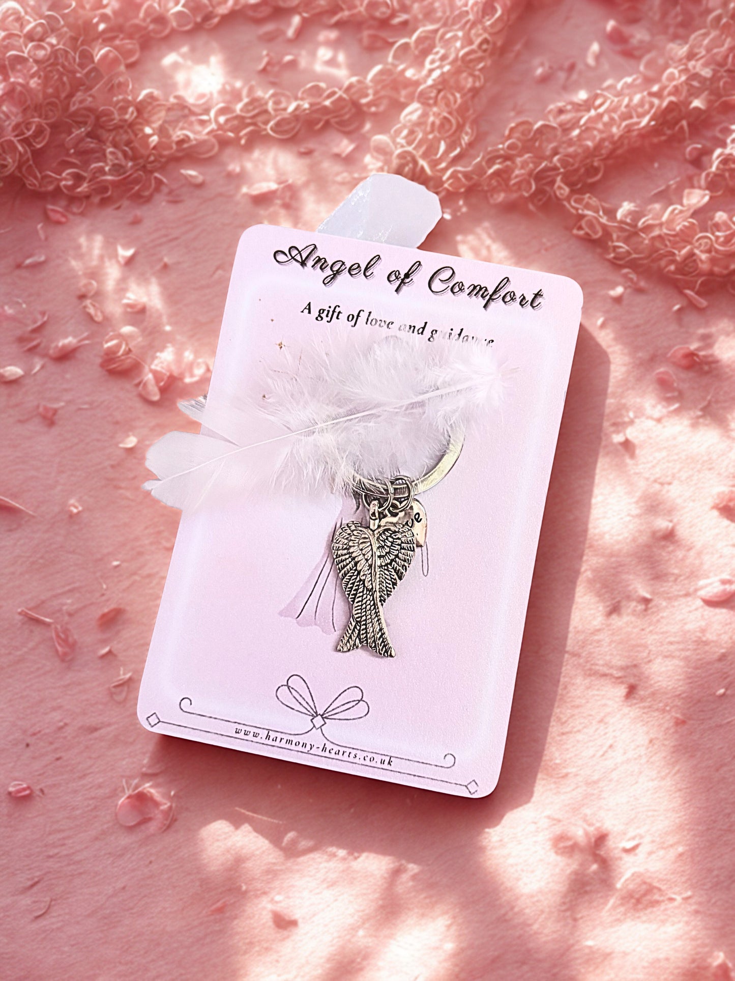 Angel of Comfort keyring on a pink textured background