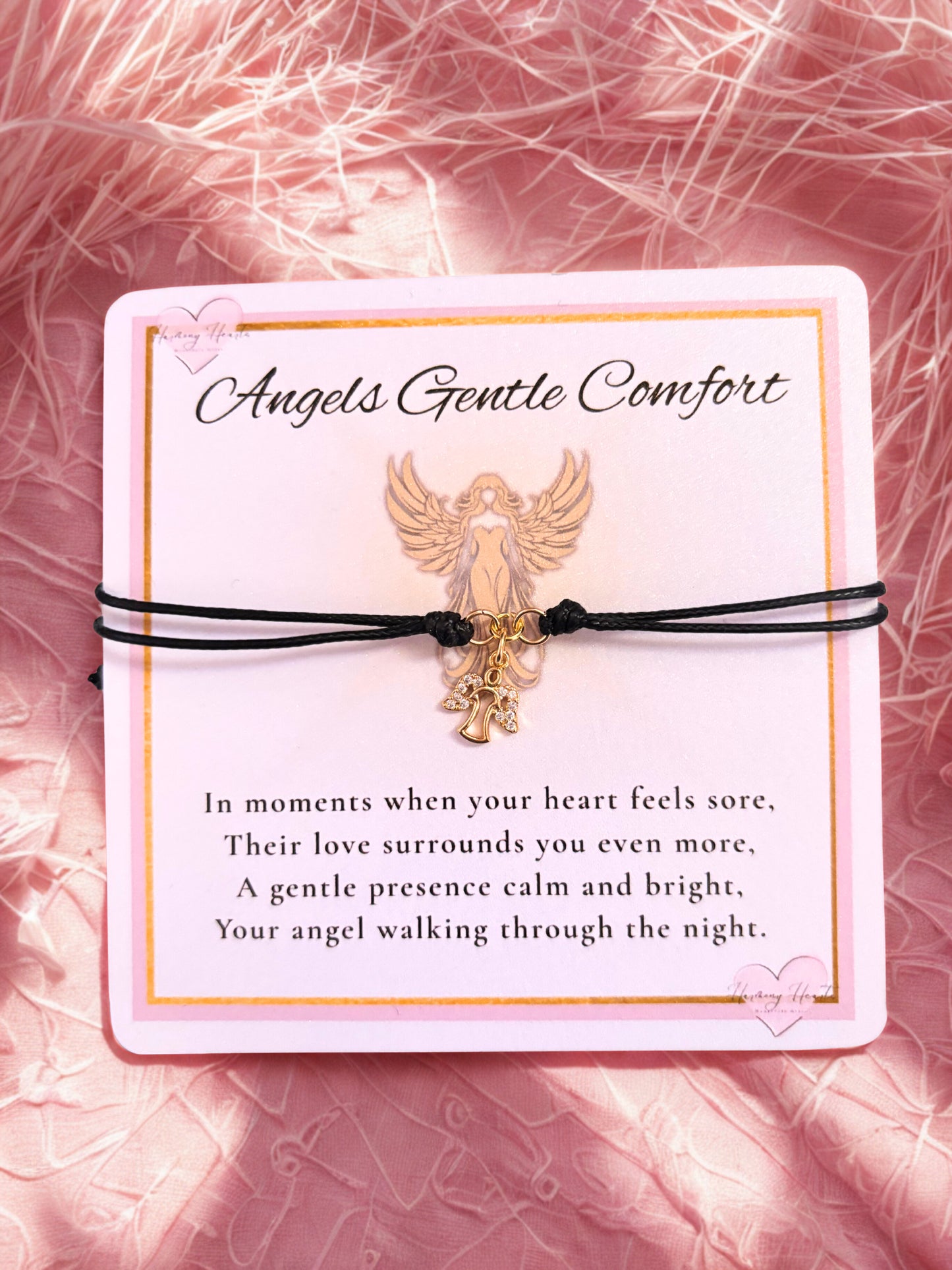 Bracelet with angel charm on a pink textured background