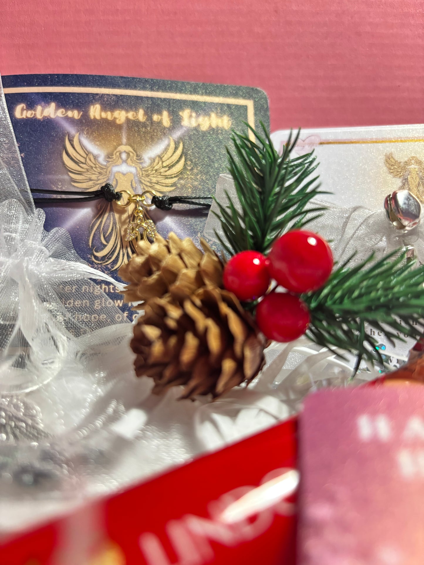 Decorative Christmas ornament with pine cone and berries on a pink background