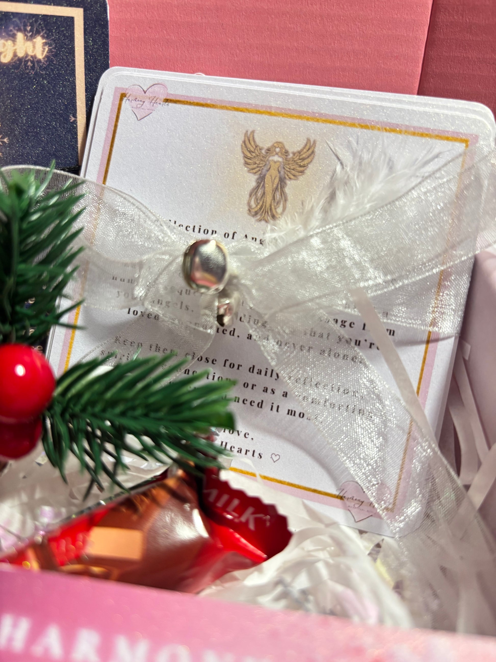 Decorative card with a bell and greenery on a pink surface