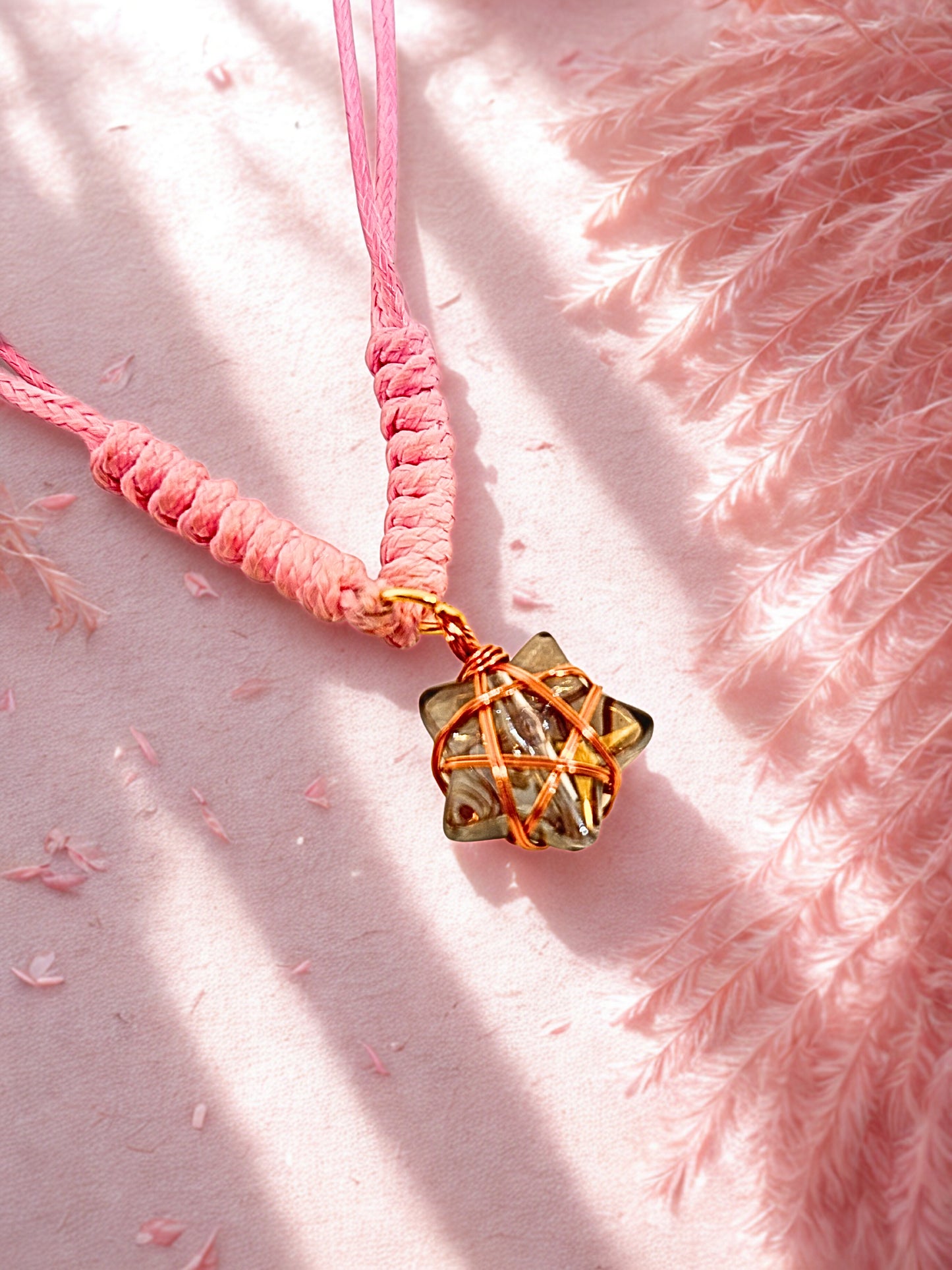 Pink cord bracelet with a star charm wrapped in rose gold wire