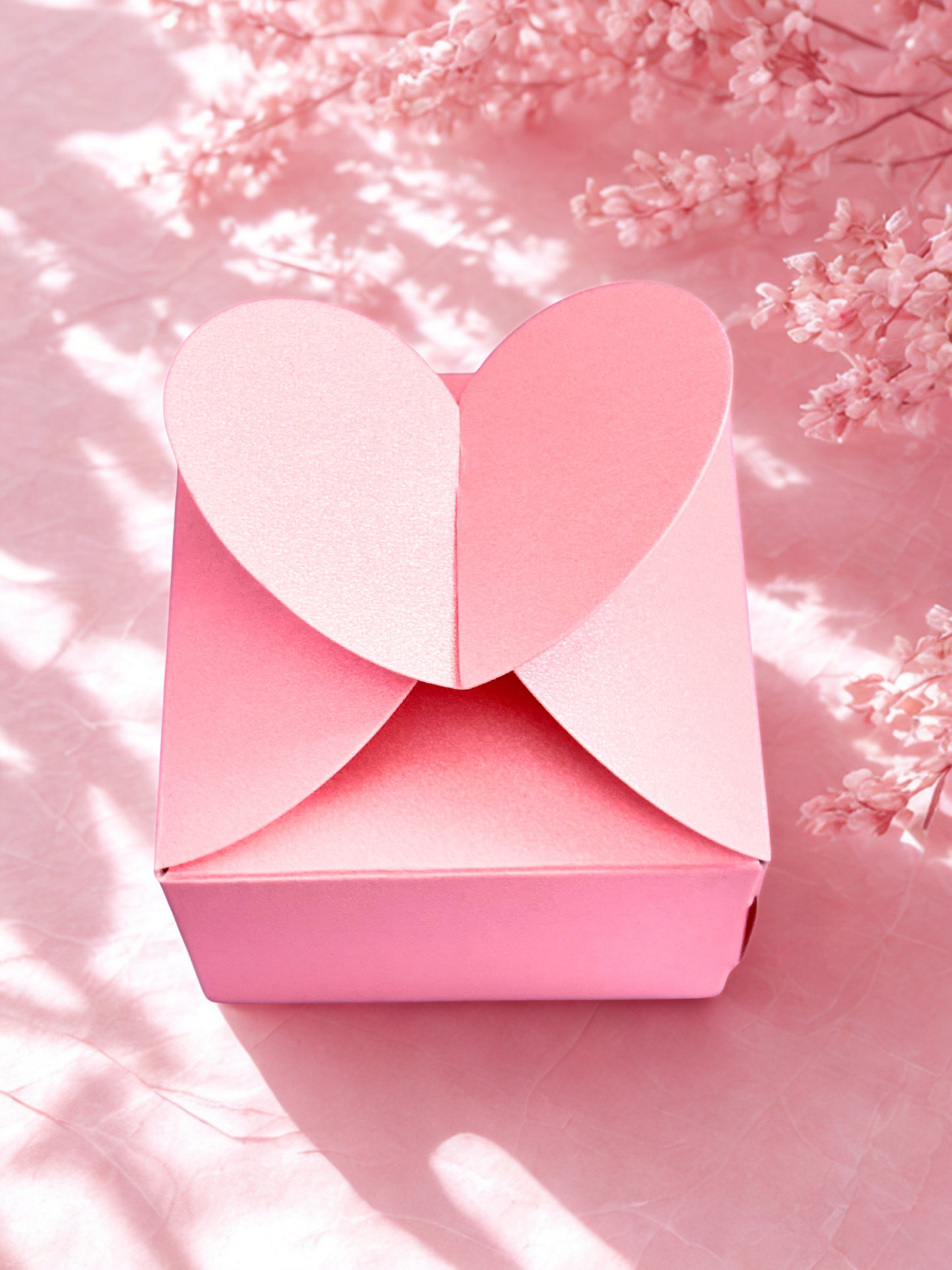 Pink heart-shaped box on a pink floral background