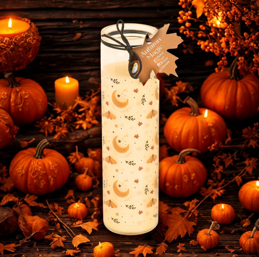 Candle with autumn design surrounded by pumpkins and leaves on a wooden surface