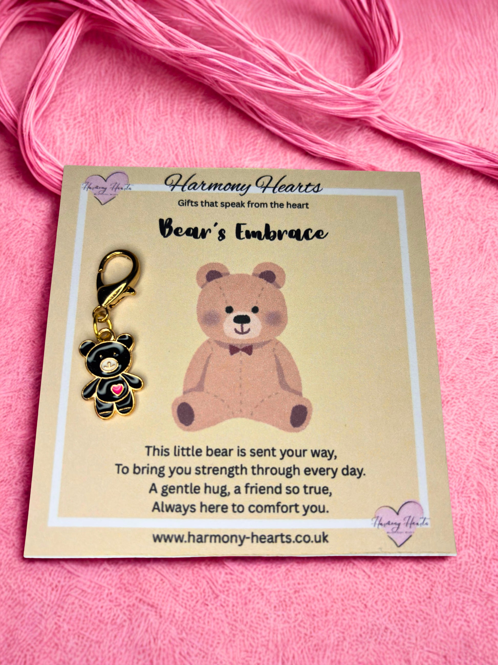 Bear-shaped keychain on a card with 'Harmony Hearts' branding against a pink background