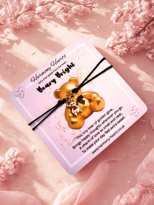 Decorative card with a gold bear charm on a pink floral background