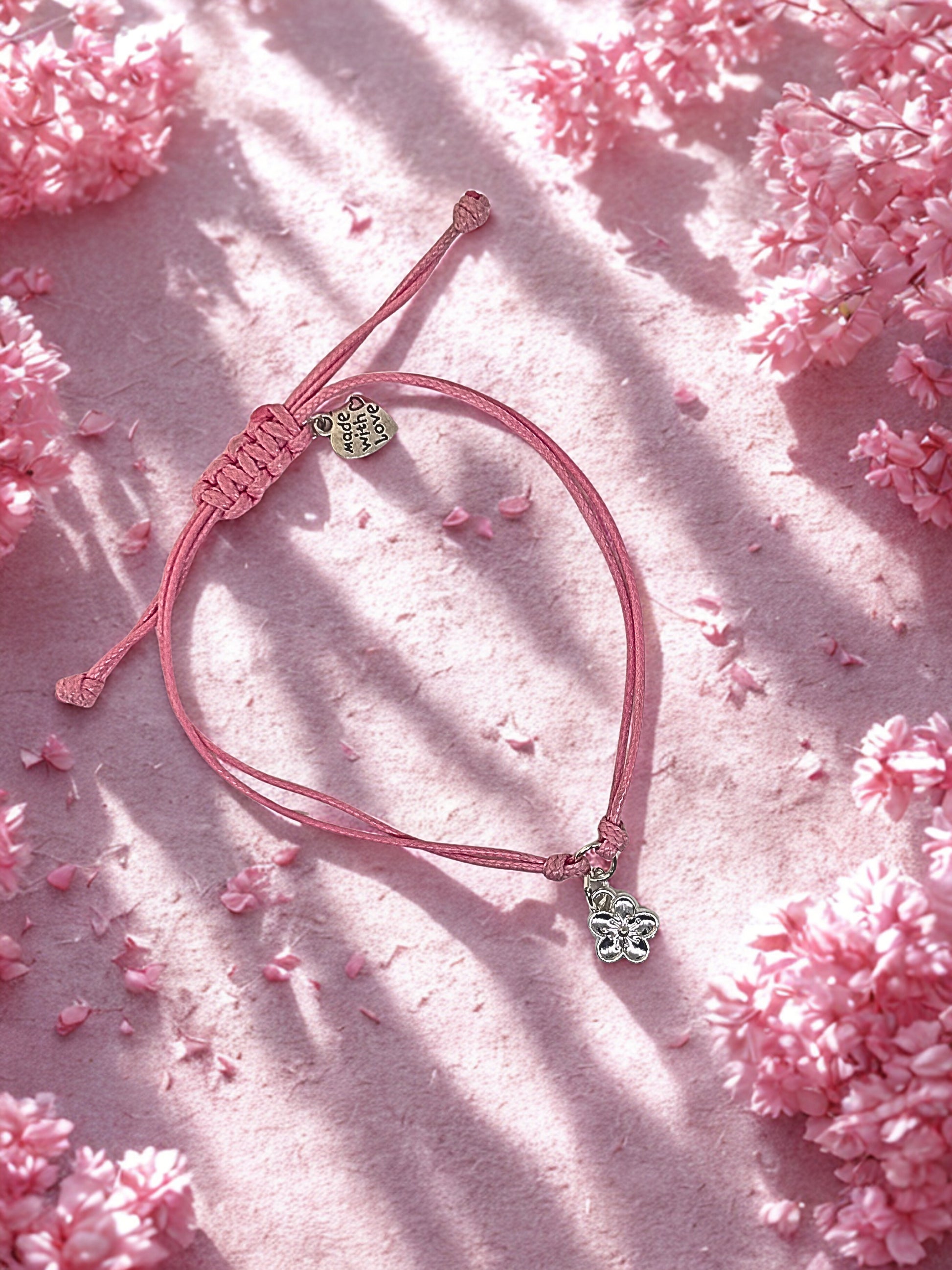 Pink bracelet with charms on a pink floral background