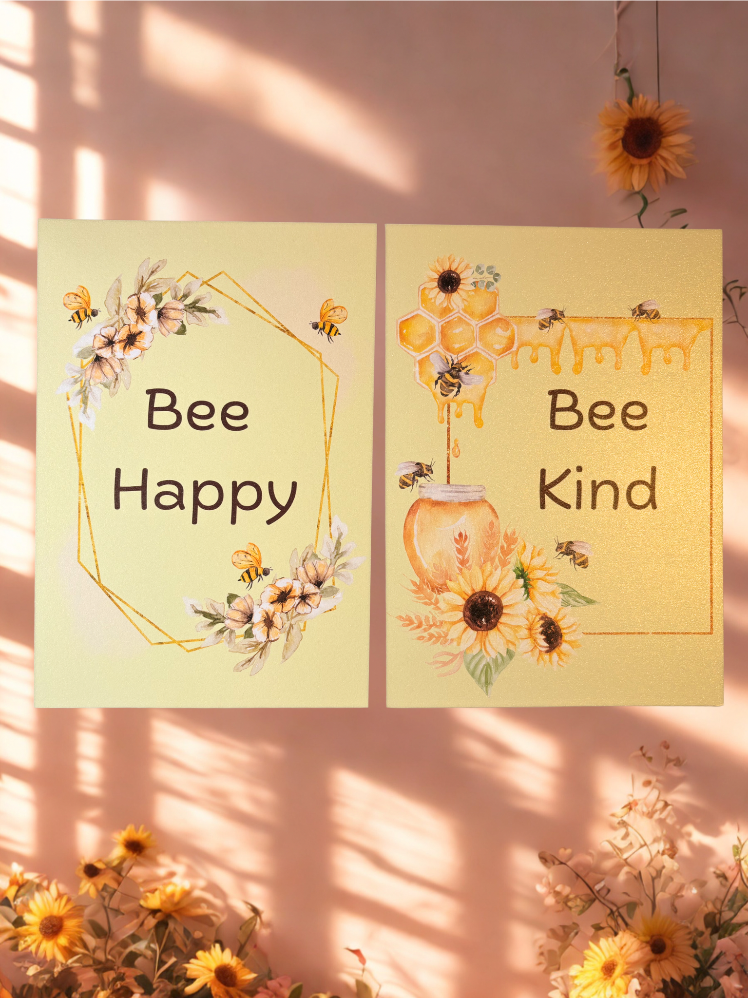 Two motivational prints with 'Bee Happy' and 'Bee Kind' text, surrounded by sunflowers on a pink background.
