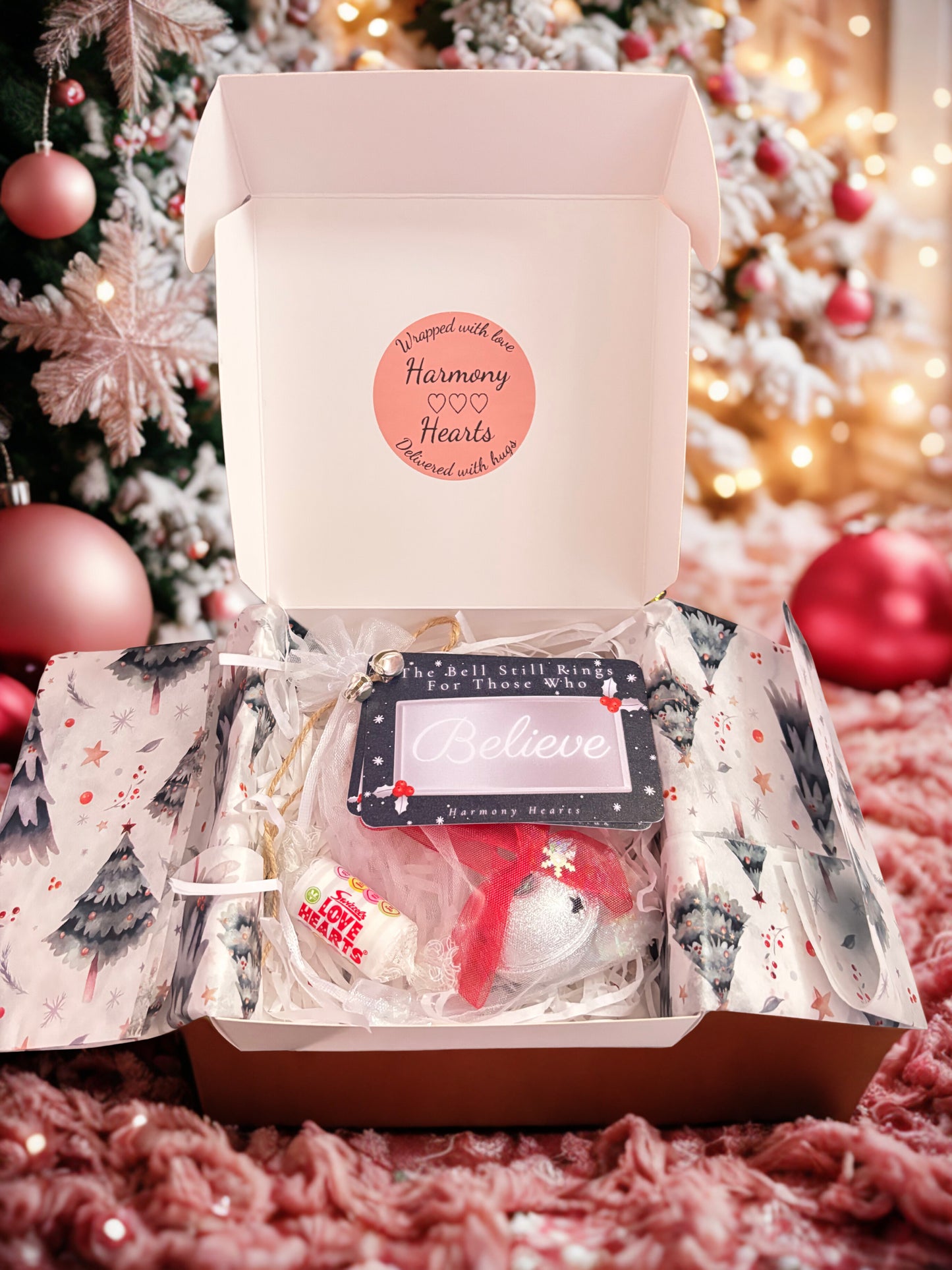 Gift box with Believe Bell and tag under a Christmas tree