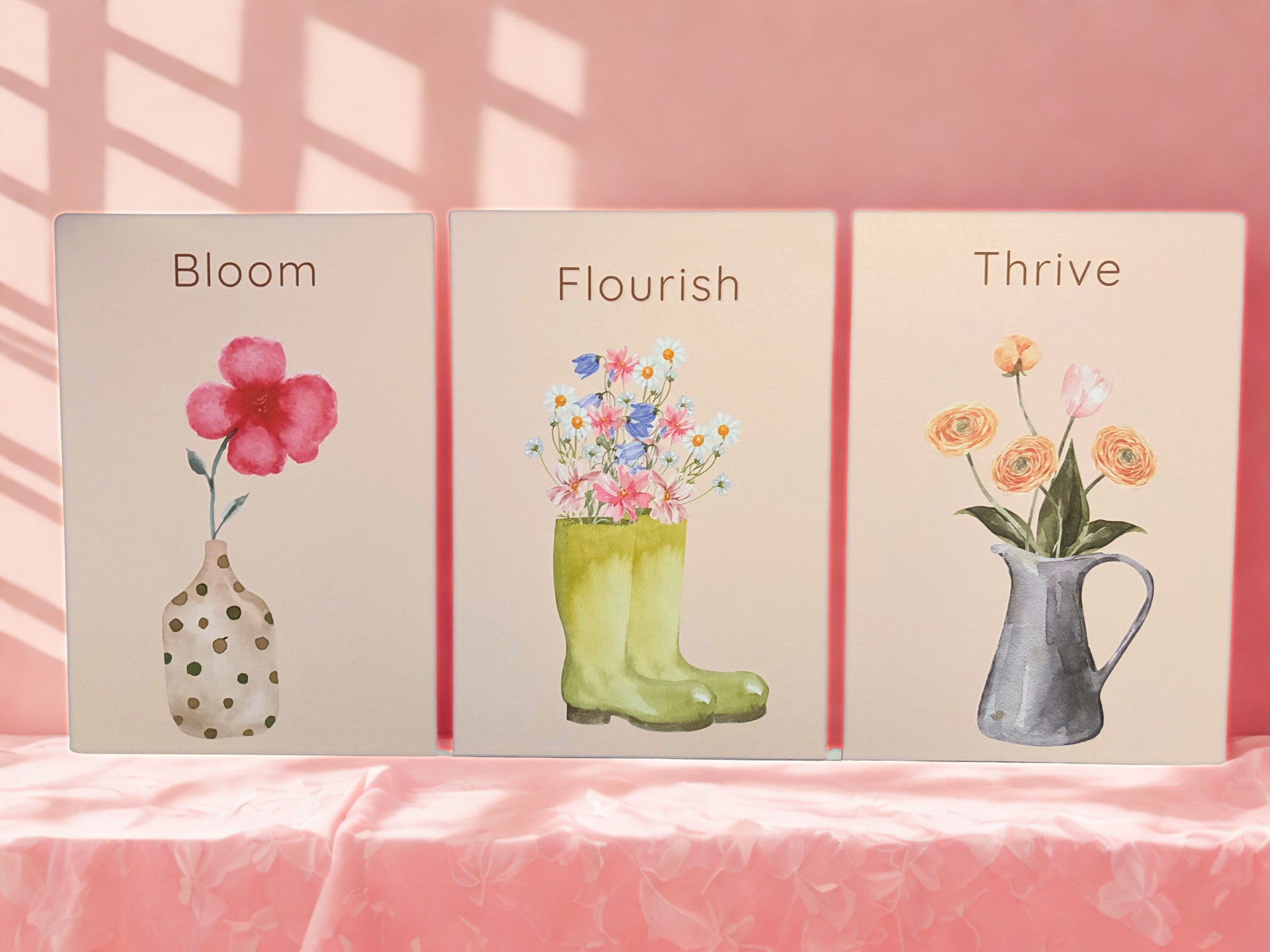 Three motivational cards with floral illustrations and text on a pink background