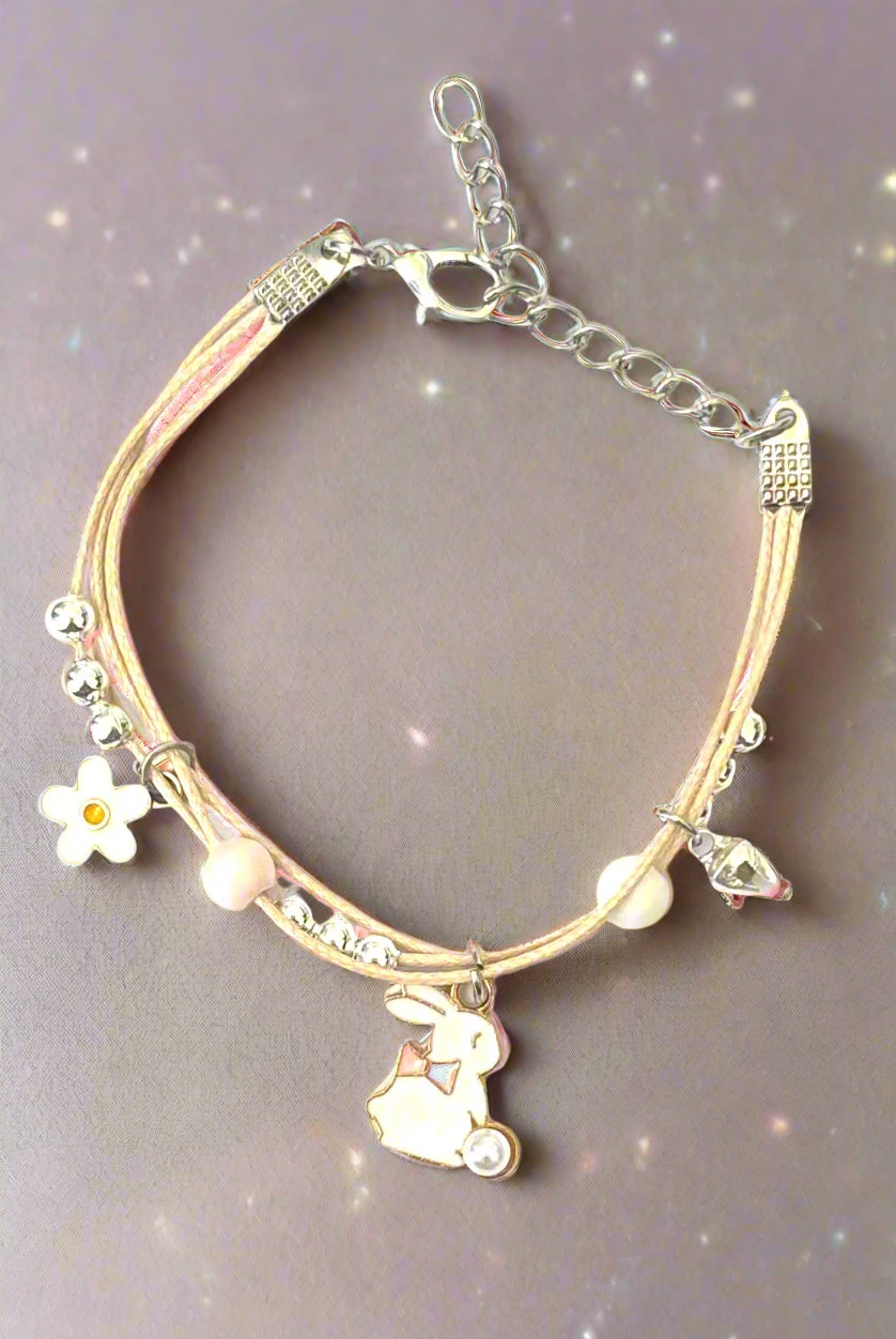 Bracelet with rabbit and flower charms on a satin background