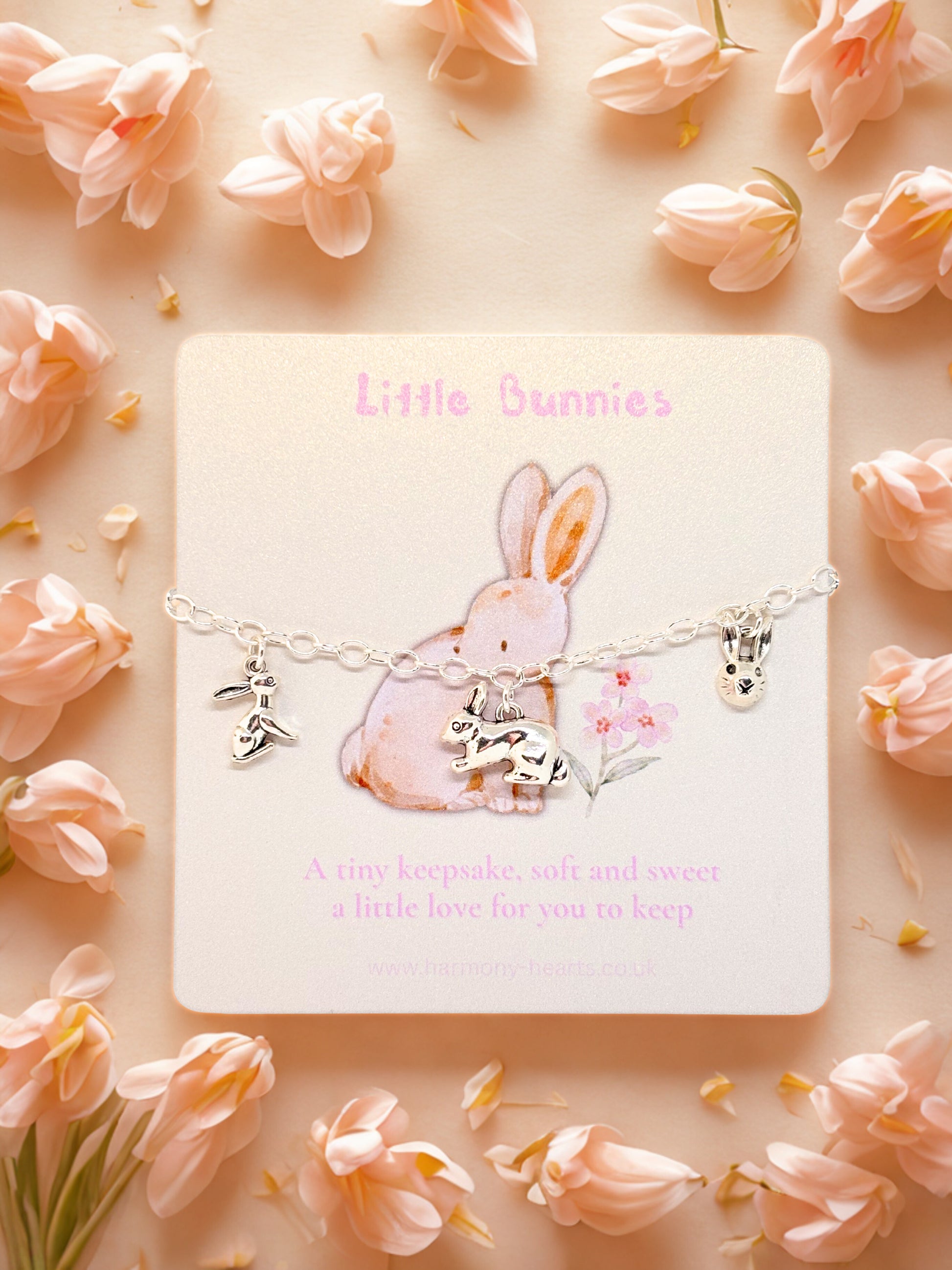 Bunny charm bracelet on a card with pink flowers around