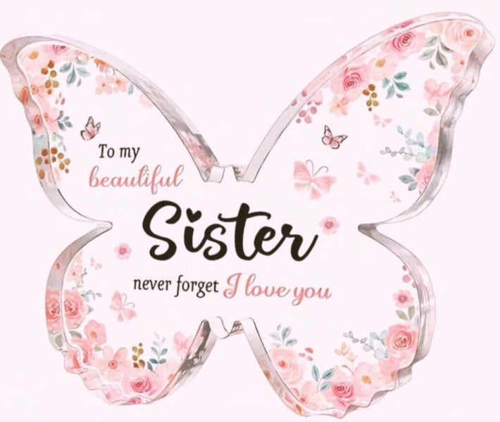 Butterfly-shaped plaque with floral design and message to sister on a white background