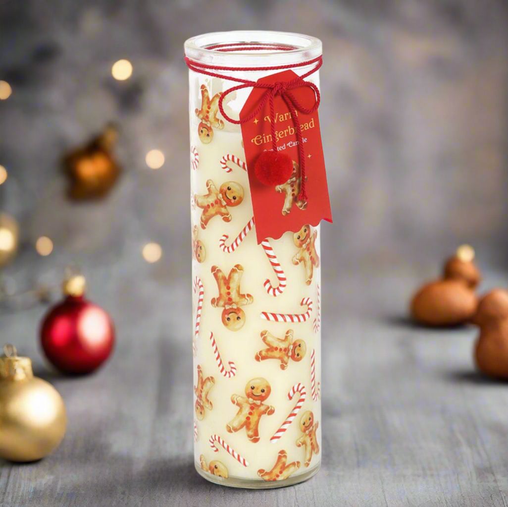 Decorative candle with gingerbread men pattern and red ribbon on a blurred Christmas background