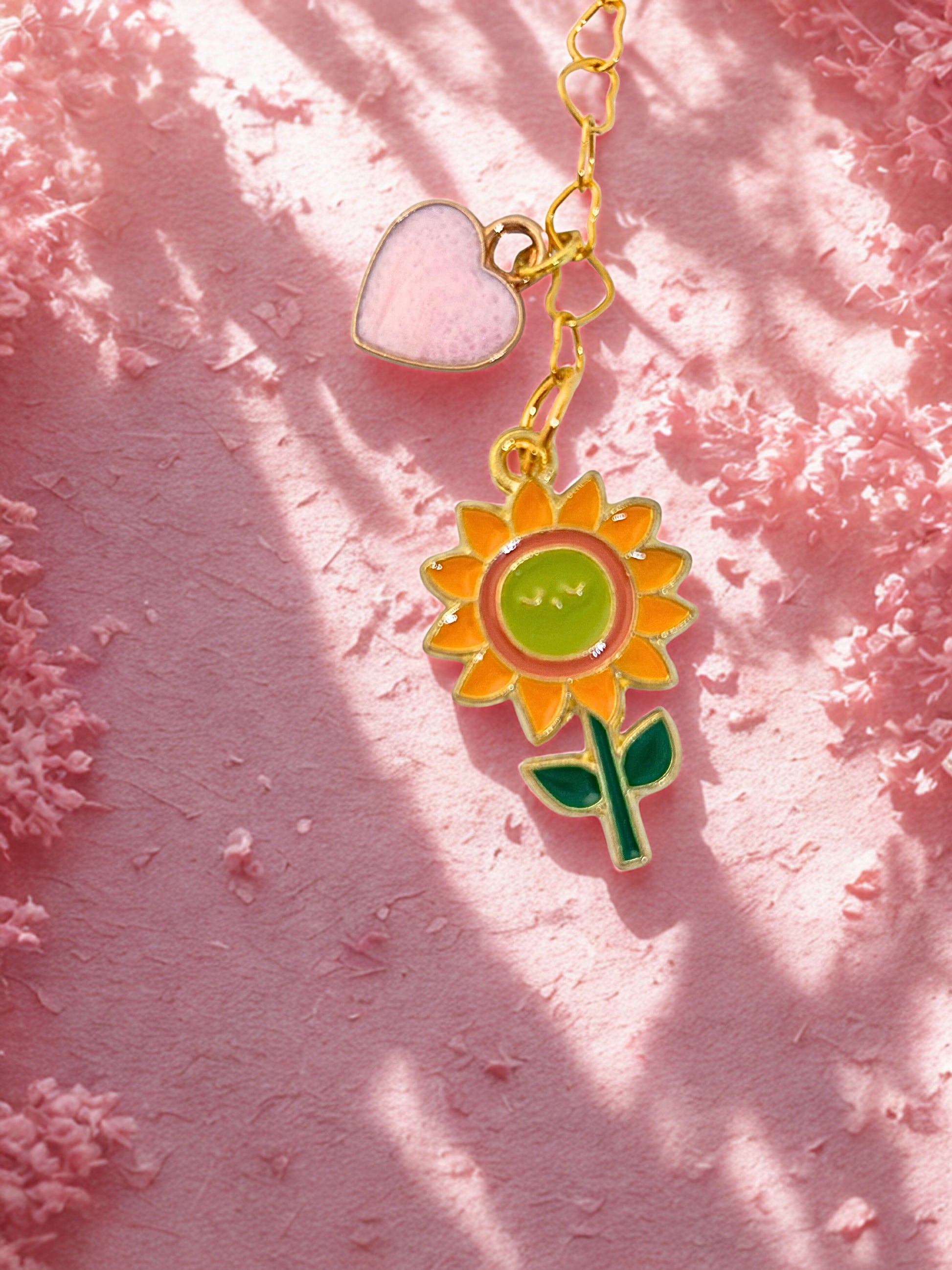 Sunflower charm with a heart on a pink textured background
