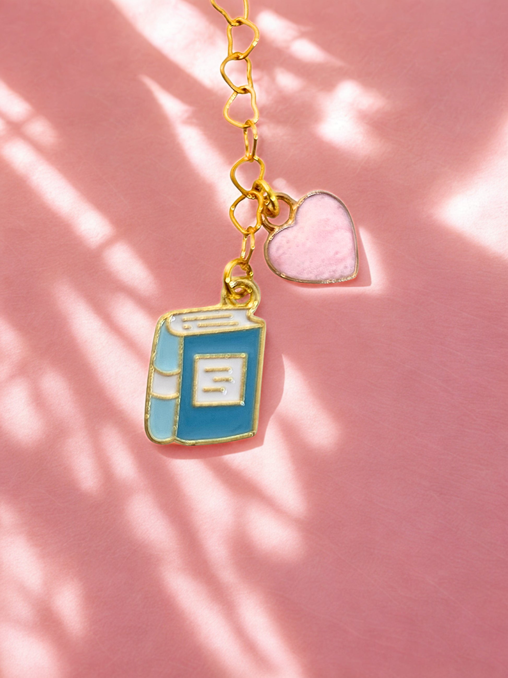 Book-shaped charm with a heart on a pink background