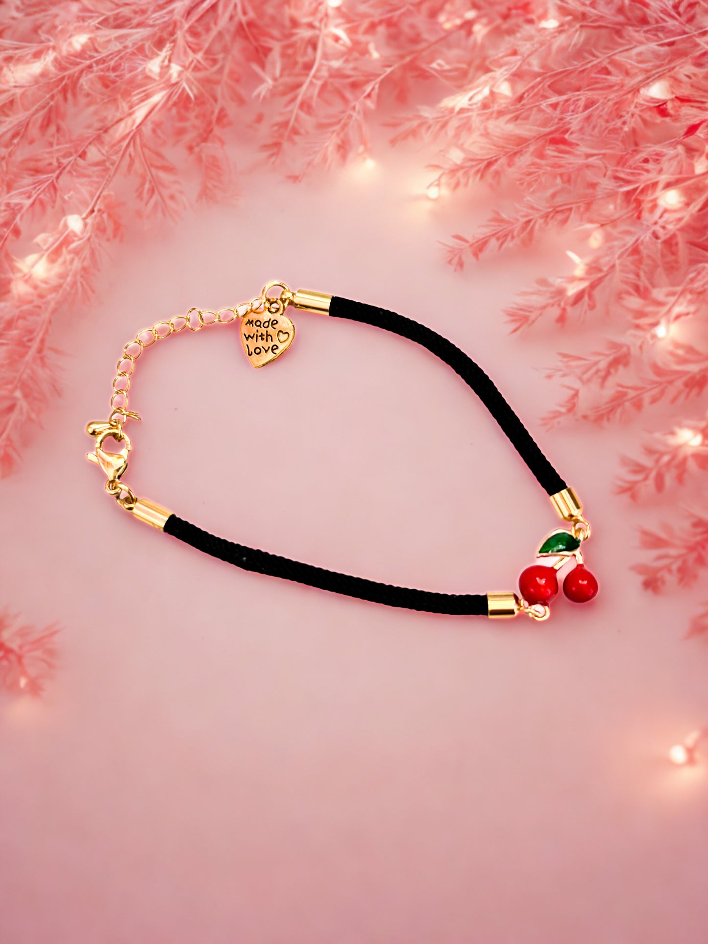 Bracelet with cherry charm and cherry decorations on a pink floral background