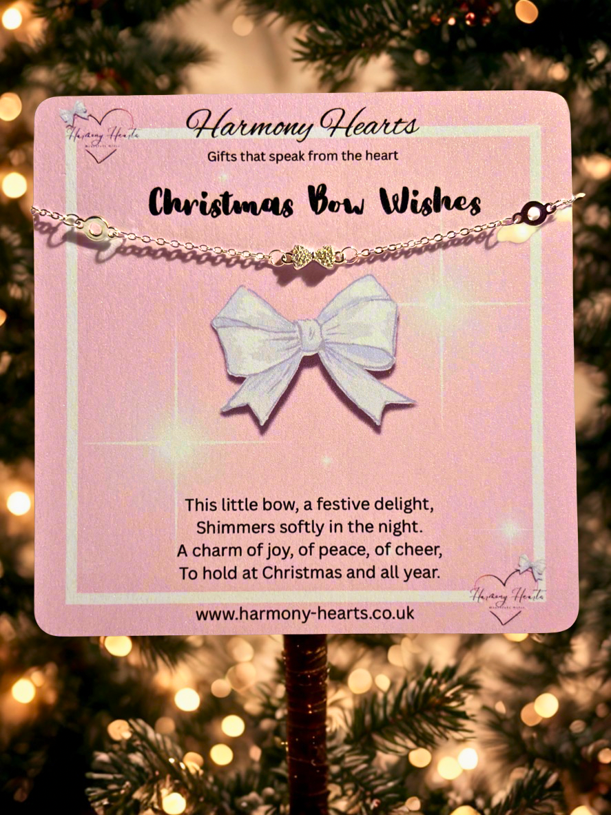 Bracelet with a bow pendant on a pink card against a Christmas tree background