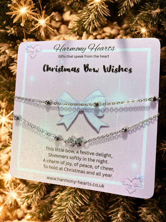 Jewelry set with a bow on a card labeled 'Harmony Hearts' against a Christmas tree background.