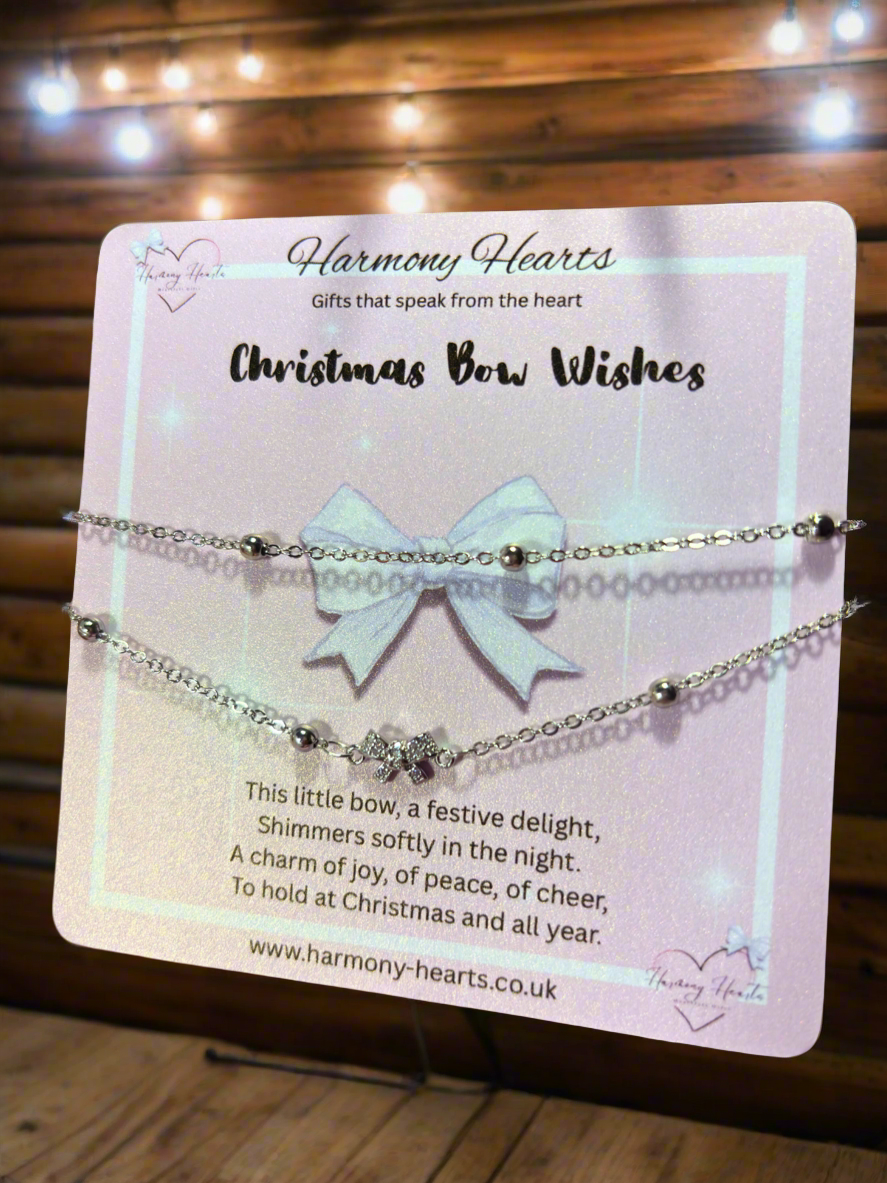 Bracelet with bow charm on a 'Harmony Hearts' branded card with text.