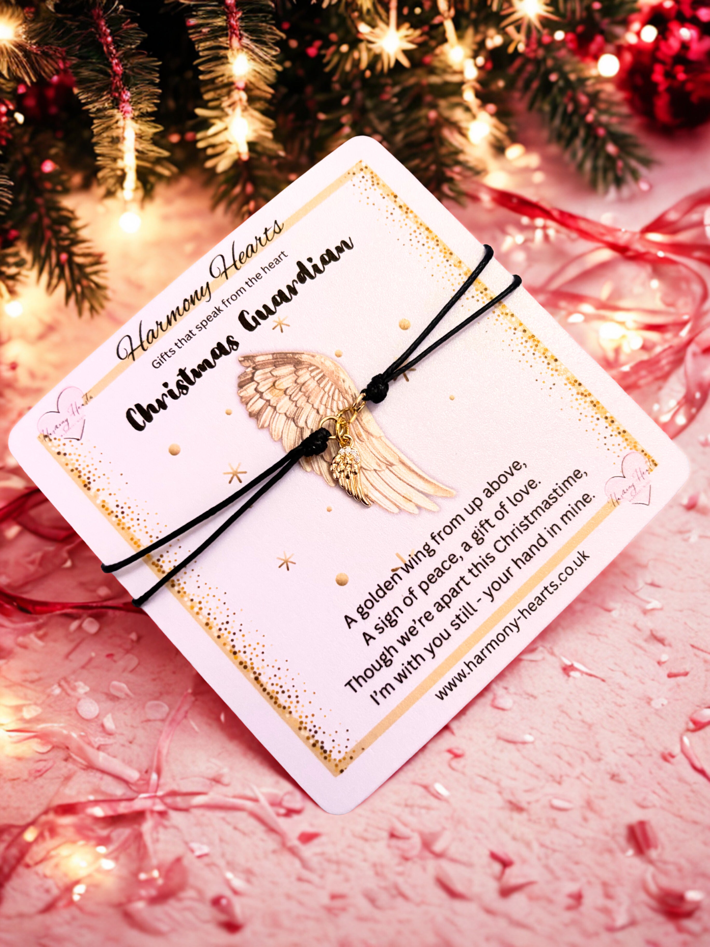 Angel wing bracelet on a card with Christmas lights and decorations in the background