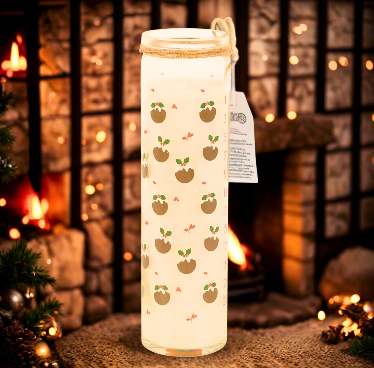 Decorative candle with christmas pudding pattern in front of a fireplace