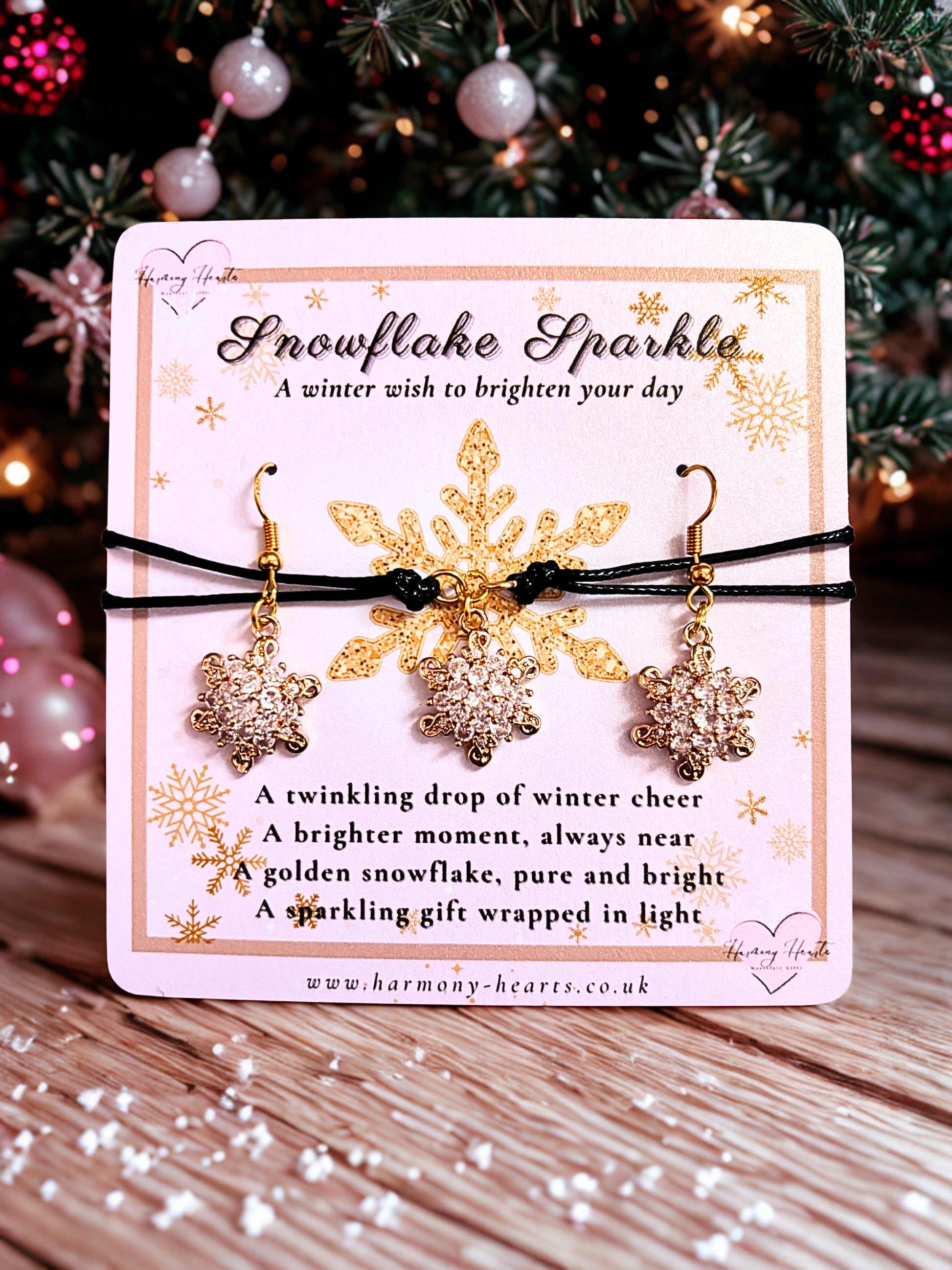Snowflake earrings and a bracelet on a decorative card with Christmas tree in the background