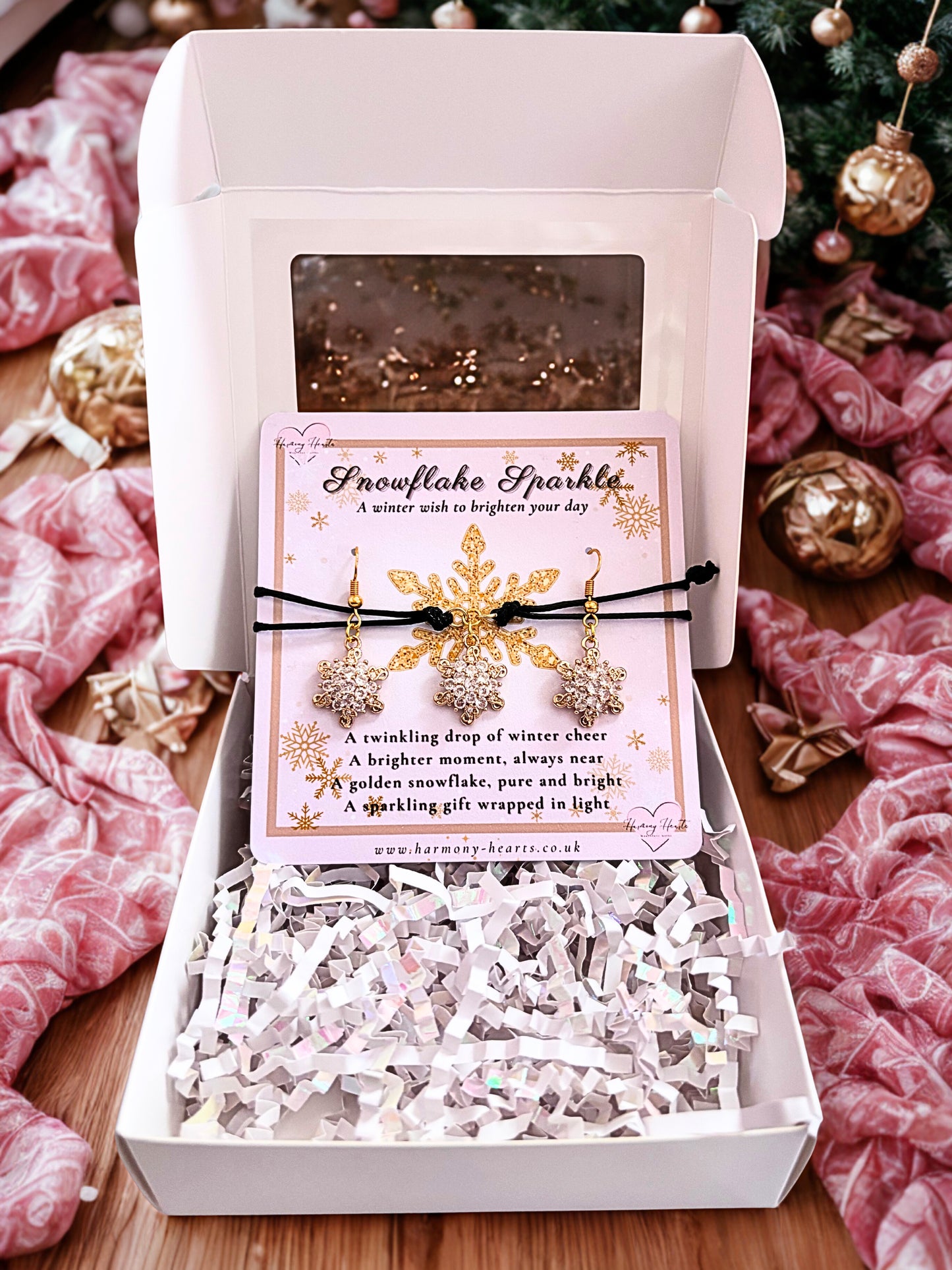 Snowflake earrings and bracelet in a decorative box with a card on a festive background