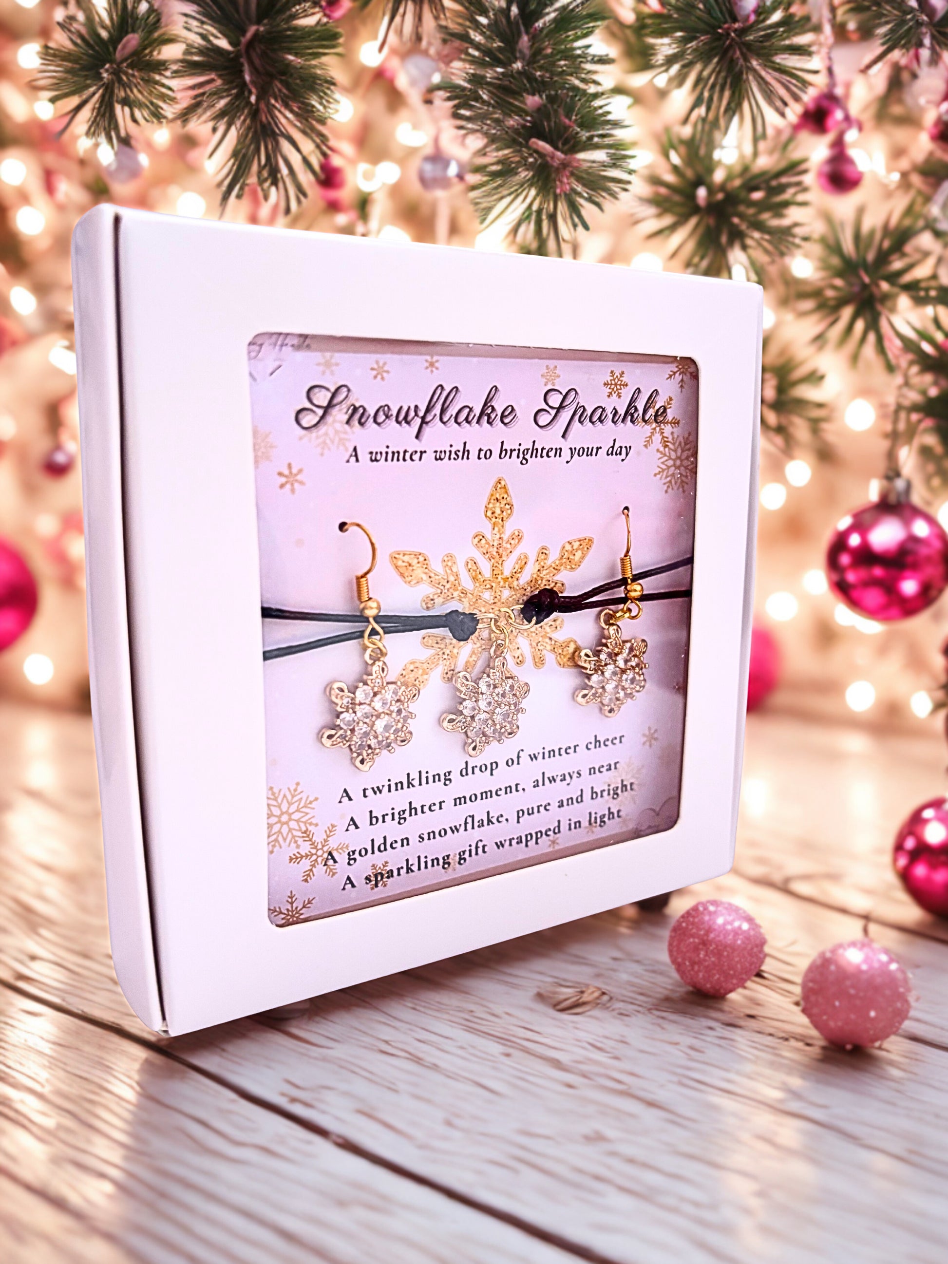 Snowflake-themed earrings and bracelet in a decorative box with Christmas decorations in the background