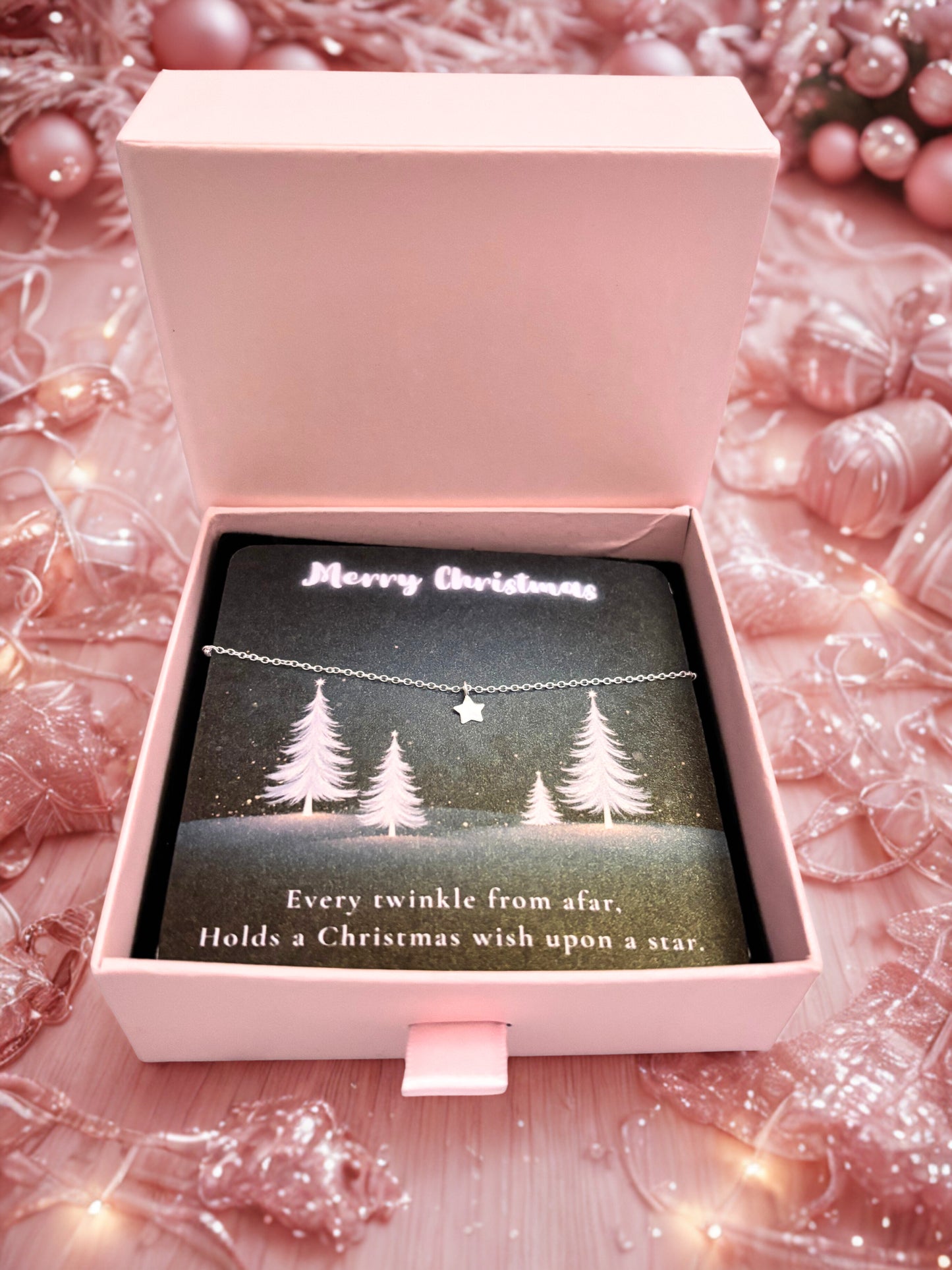 Star bracelet with Christmas tree design card in a pink box on a festive background